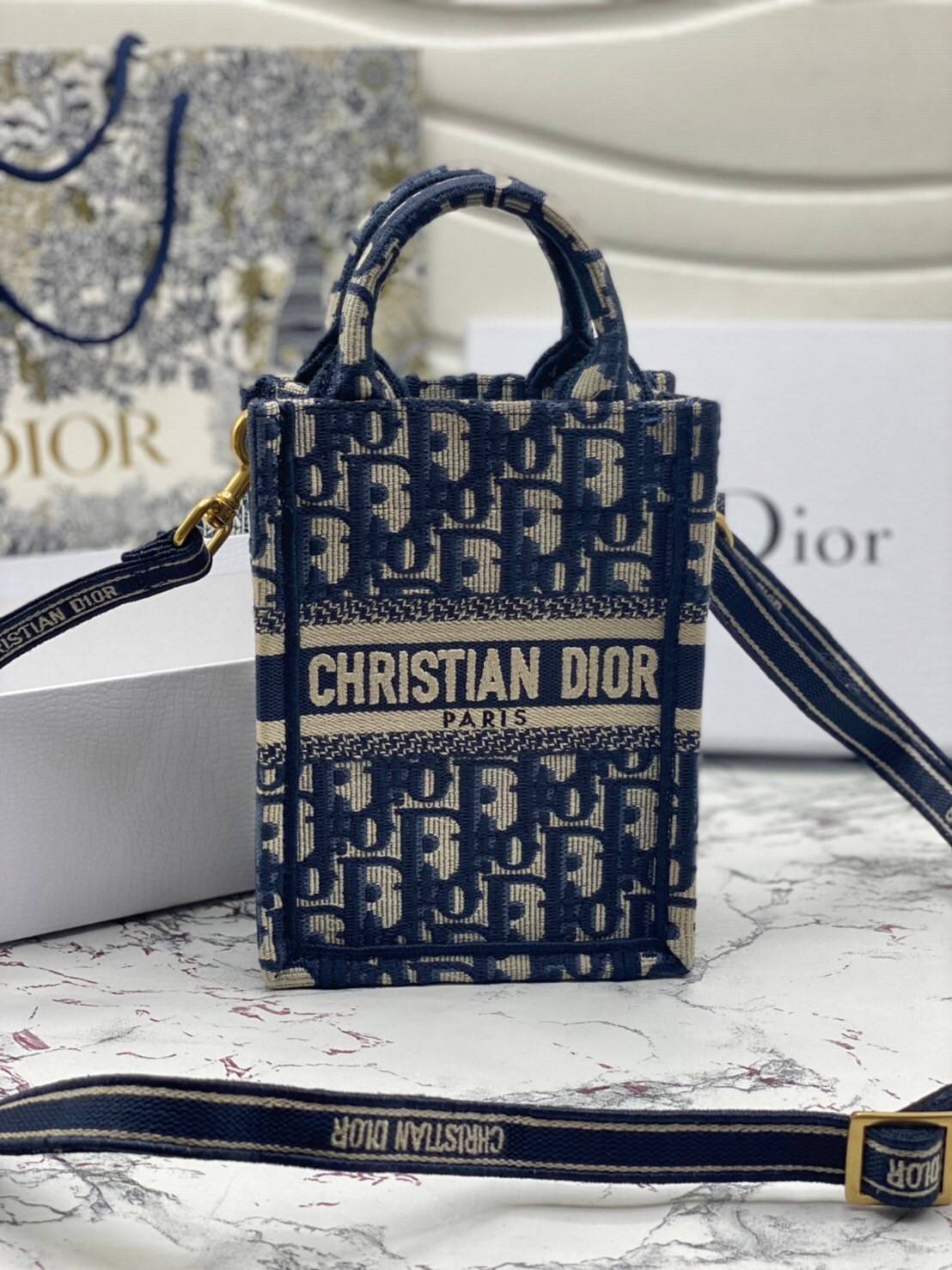 ORI 】Mini Dior Book Tote Phone Bag Blue Dior Oblique Embroidery พร้อมส่งที่ไทย ภาพสินค้าถ่ายจากงานขายจริง ใช้งานต่างประเทศได้ กระเป๋าใบมินิจะใส่โทรศัพท์ได้เช่นเดียวกับของใช้จำเป็นเล็กๆ น้อยๆ ในแต่ละวัน มาพร้อมสายสะพายไหล่แบบปักที่ปรับได้และถอดออกได้ อุปกร