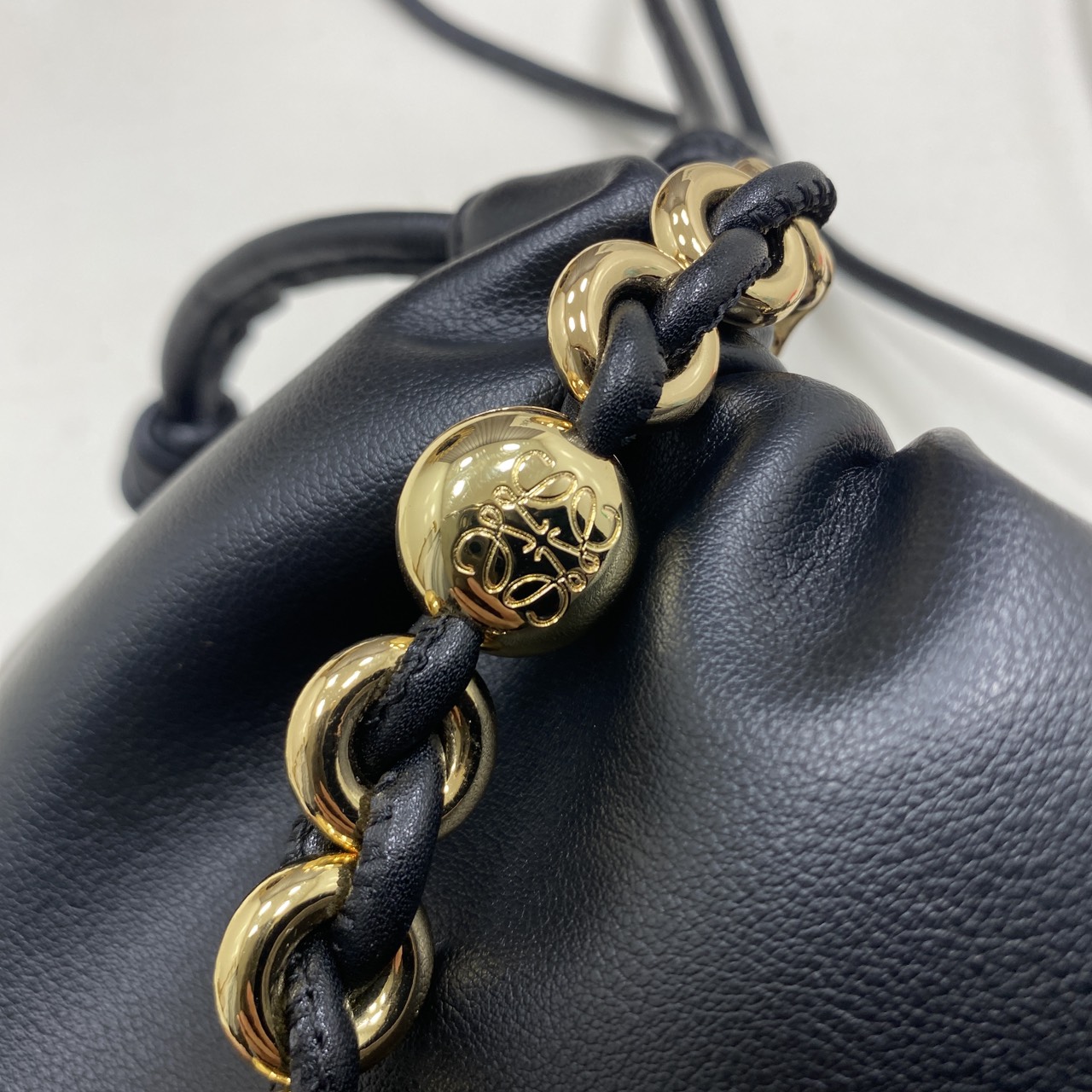 ORI หนังแท้ | LOEWE Mini Flamenco purse in mellow nappa leather / Loewe Bucket Bag กระเป๋าสะพายทรงบัคเก็ตไซส์มินิ หนังเรียบสวยหรู เรียบง่าย หนังแท้ผิวสัมผัสนุ่มมือ น้ำหนักเบาและนุ่มสบาย ดีไซน์จับจีบ เชือกผูกแบบปมโบราณ และสายโซ่รูปโดนัท