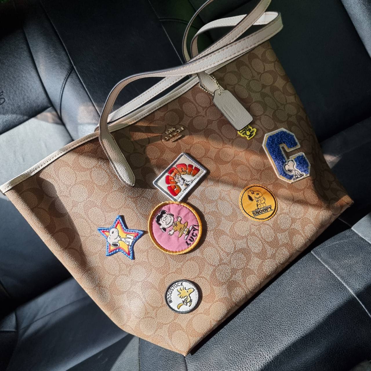 COACH C4292 COACHxPEANUTS CITY TOTE IN SIGNATURE CANVAS WITH VARSITY PATCHES กระเป๋าทรงโท้ทใบใหญ่ กับคอลเลคชั่นคอลแลบใหม่ล่าสุด น่ารักด้วยเหล่าผองเพื่อนสนู้ปพี สวยโดดเด่นมากๆ ใบนี้ใส่ของได้ของครบครัน จุได้แบบไม่ต้องกลัวเต็ม!! วัสดุหนังแคนวาสคุณภาพดี ปากกร
