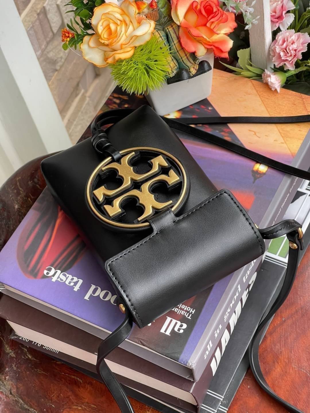 OUTLET 】TORY BURCH MILLER METAL PHONE CROSSBODY อีกหนึ่งกระเป๋าใส่มือถือรุ่นฮิตที่เชื่อว่าหลาย ๆ คนต้องเคยเห็นผ่าน ๆ ตามาอย่างแน่นอน กับแบรนด์ Tory Burch ดีไซน์กระเป๋าทรงฝาพับแม่เหล็กใช้งานง่าย มาพร้อมดีเทล Logo แบรนด์โดดเด่นสีทองตัดกับหนังแกะสีดำ ดูหรูดู