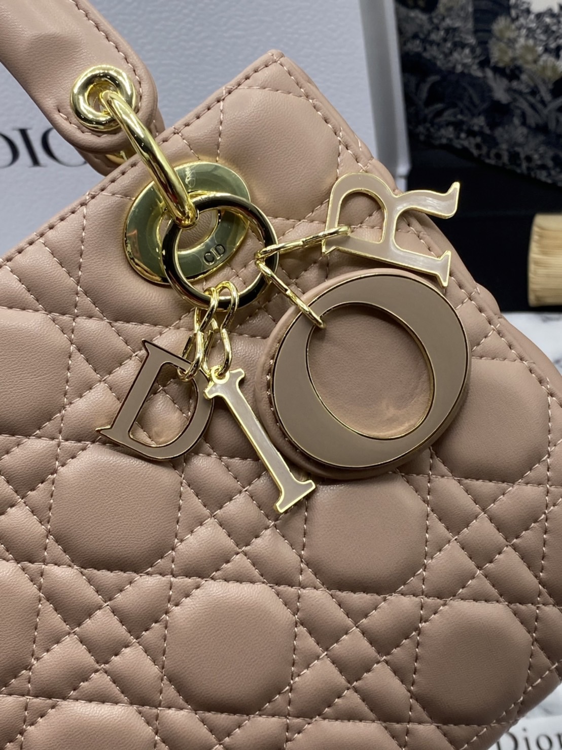 หนังแท้ DIOR LADY BAG 20cm ความสง่างามอีกหนึ่งรุ่นของ Dior รูปทรงสีเหลียม ขนาดกระทัดรัด ตั้งอยู่ทรง ฐานกระเป๋าแข็งแรง มีหมุดรองฐาน ดีไซน์ที่มีเอกลักษณ์เฉพาะตัว ด้านหน้าตกแต่งด้วยตัวอักษร D.I.R ห้อยเป็นพวงกุญแจ จะถือด้วยมือหรือสะพายไหล่ก็ดูดีมากๆ ค่ะ