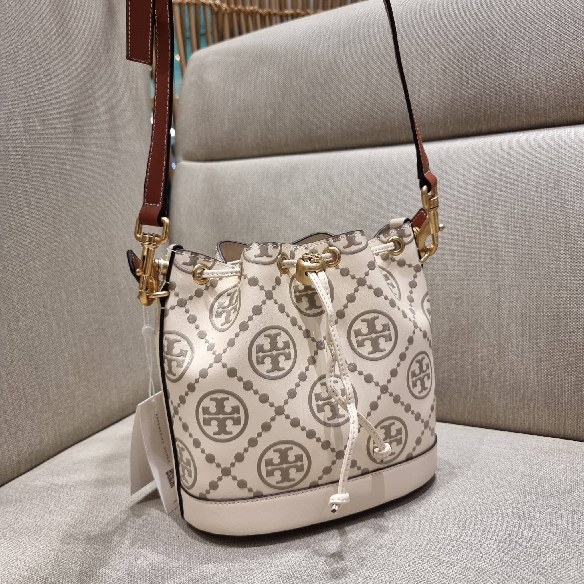 TORY BURCH T MONOGRAM EMBOSSED BUCKET BAG คอลเลคชั่นใหม่ กับกระเป๋าบัคเก็ตทรงยอดนิยม ดีไซน์ใหม่ล่าสุด สวยลูกคุณหนู หรูหรา!! ด้วยดีเทลผิวลายนูนลวดลายเอกลักษณ์ วัสดุหนังแท้ ปากกระเป๋ารูดเปิด-ปิดได้ มีหูจับในตัว สะดวกใช้ไปอีก และมีสายสะพายข้าง ปรับได้อีกด้วย