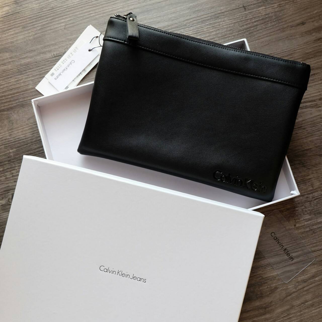 Cluth Bag Calvin Klein Cluth Bag กระเป๋าถือ ทรงคลัทช์ จากแบรนด์ Calvin Klein ด้านหน้า ปั๊มโลโก้แบรนด์ เปิด - ปิดกระเป๋าด้วยซิป ด้านในแบ่งเก็บของ ได้ 2 ช่องใหญ่ และมีช่องใส่บัตร 1 ช่อง สามารถใส่ iPad Mini ได้ค่ะ