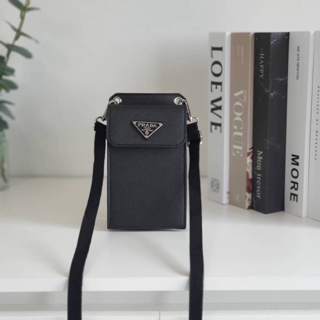 PRADA PHONE CASE ไอเท็มสุดคลาสสิคที่ทุกท่านควรมี! Prada Saffiano Leather Smartphone Case งานพรีเมี่ยมกิ้ฟท์จากเคาเตอร์ต่างประเทศ ของมีจำนวนจำกัด หนังลาย saffiano อยู่ทรงสวย ดีไซน์หรูหรา ดูดี ทรงCrossbody ด้านหน้ามีโลโก้แบรนด์ อะไหล่ทอง ด้านในเปิดปิดด้วยกร