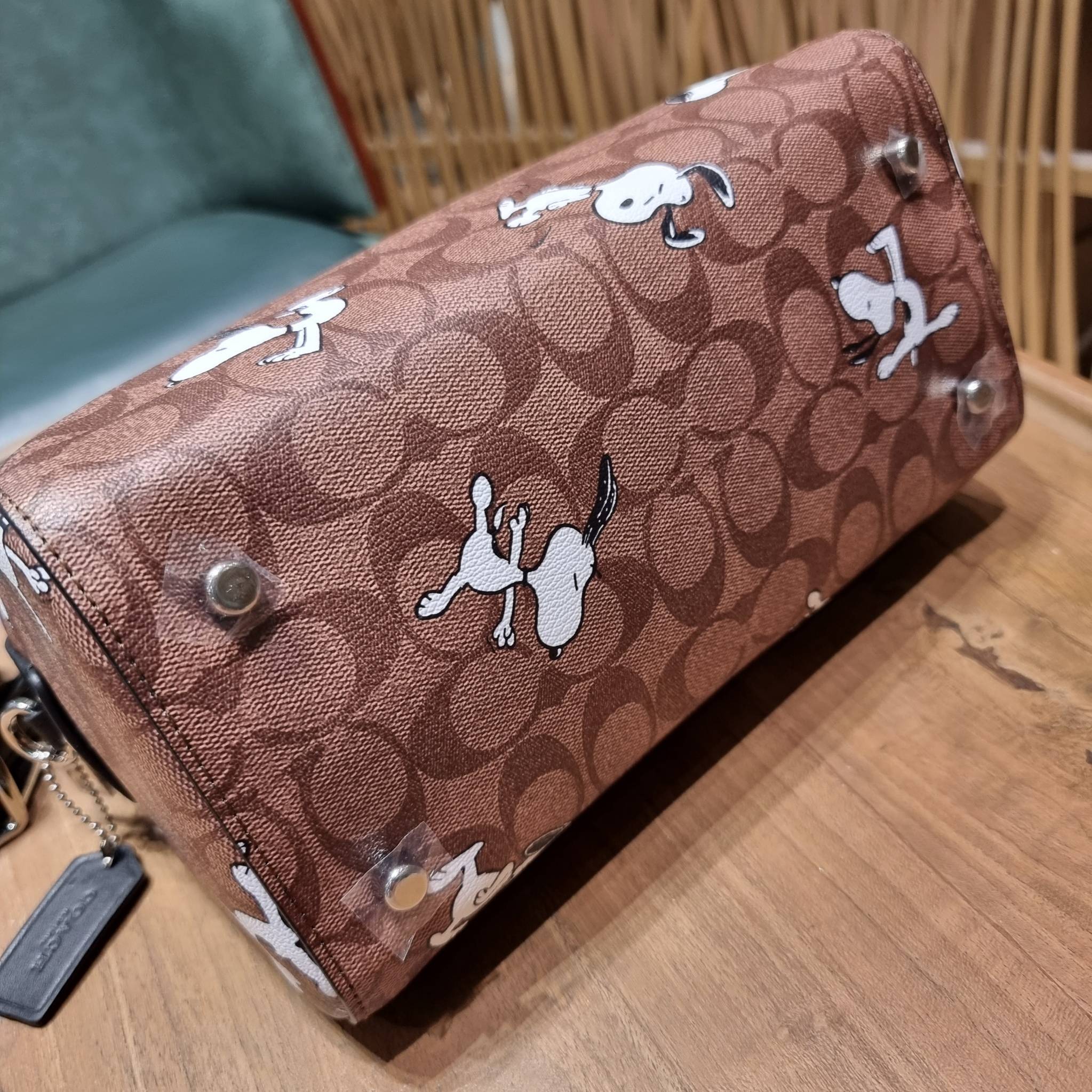 COACH C4118 COACH x PEANUTS ROWAN SATCHEL IN SIGNATURE CANVAS WITH SNOPPY PRINT สนูปพีที่สุดของคอลเลคชั่นแห่งความน่ารัก มาในดีไซน์ของกระเป๋าทรงหมอนยอดฮิต คลาสสิคใช้งานได้ไม่มีเบื่อ รอบนี้มาให้พร้อมสายสะพาย crossbody แบบสปอร์ต ทำให้ใช้งานได้อย่างกระฉับกระเ