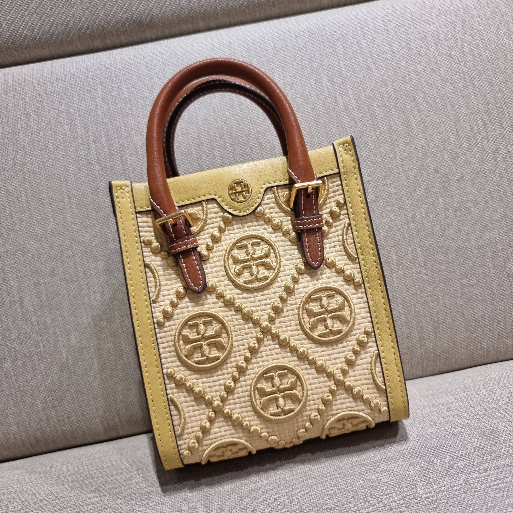 TORY BURCH T MONOGRAM STRAW MINI TOTE สวยสุด ดูแพงสุด!! ต้องยกให้เลย กับไอเท็มนี้ กระเป๋าสะพายทรงโท้ท ไซส์มินิ มีลูกเล่นที่ดีเทลเยอะมาก ด้วยงานฝีมือปักสานด้วยวัสดุจากกธรรมชาติ ถักทอเป็นลายเส้นขึ้นลายนูน ตัดขอบด้วยหนังแท้ และยังโดดเด่นด้วยหูจับในตัวโทนสีอุ