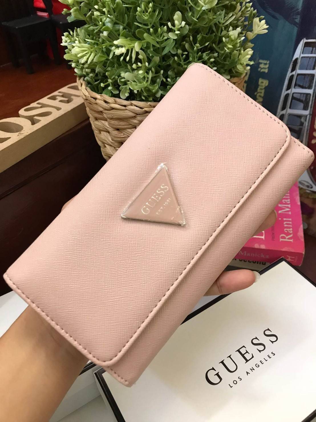 GUESS FACTORY WOMEN'S LONG WALLET กระเป๋าสตางค์ทรงยาวแบบสามพับ วัสดุหนังลายsaffiano เปิดปิดด้วยกระดุมสะดวกใช้ ภายในมีทั้งช่องซิปใส่เหรียญ ช่องใส่ธนบัตรและช่องใส่บัตรหลายช่องและช่องใส่รูปแยกเป็นสัดส่วน ด้านหน้ามีโลโก้แบรนด์ทรงสามเหลี่ยม ด้านหลังมี1ช่อ
