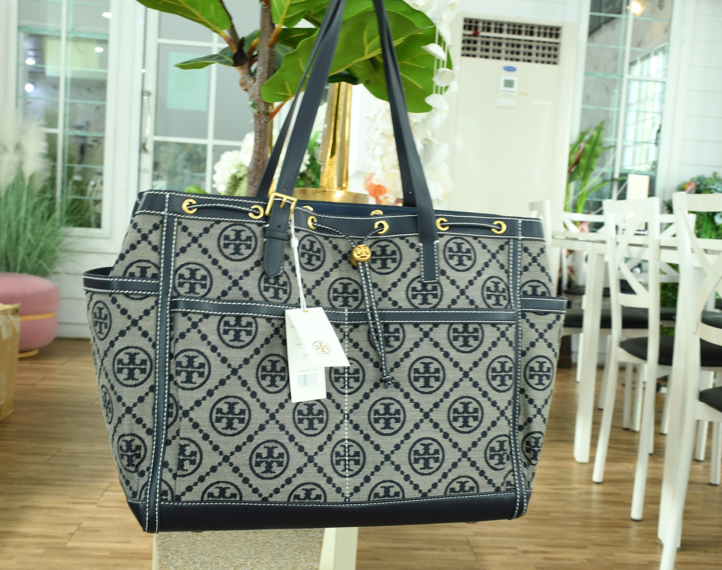 OUTLET 】TORY T MONOGRAM JACQUARD WFH TOTE กระเป๋าถือหรือสะพายไหล่ วัสดุ Canvas ปักษ์ลายแบรนด์ อะไหล่ทองสวยหรู น้ำหนักเบา จุของได้เยอะ ด้านหน้ามีกระเป๋าเล็ก2ช่อง ด้านหลัง2ช่อง ด้านในโล่ง มีช่องใหญ่1ช่อง ช่องเล็ก1ช่อง และอีก1ช่องซิป ใบใหญ่ Size XL ใส่เสื้อผ