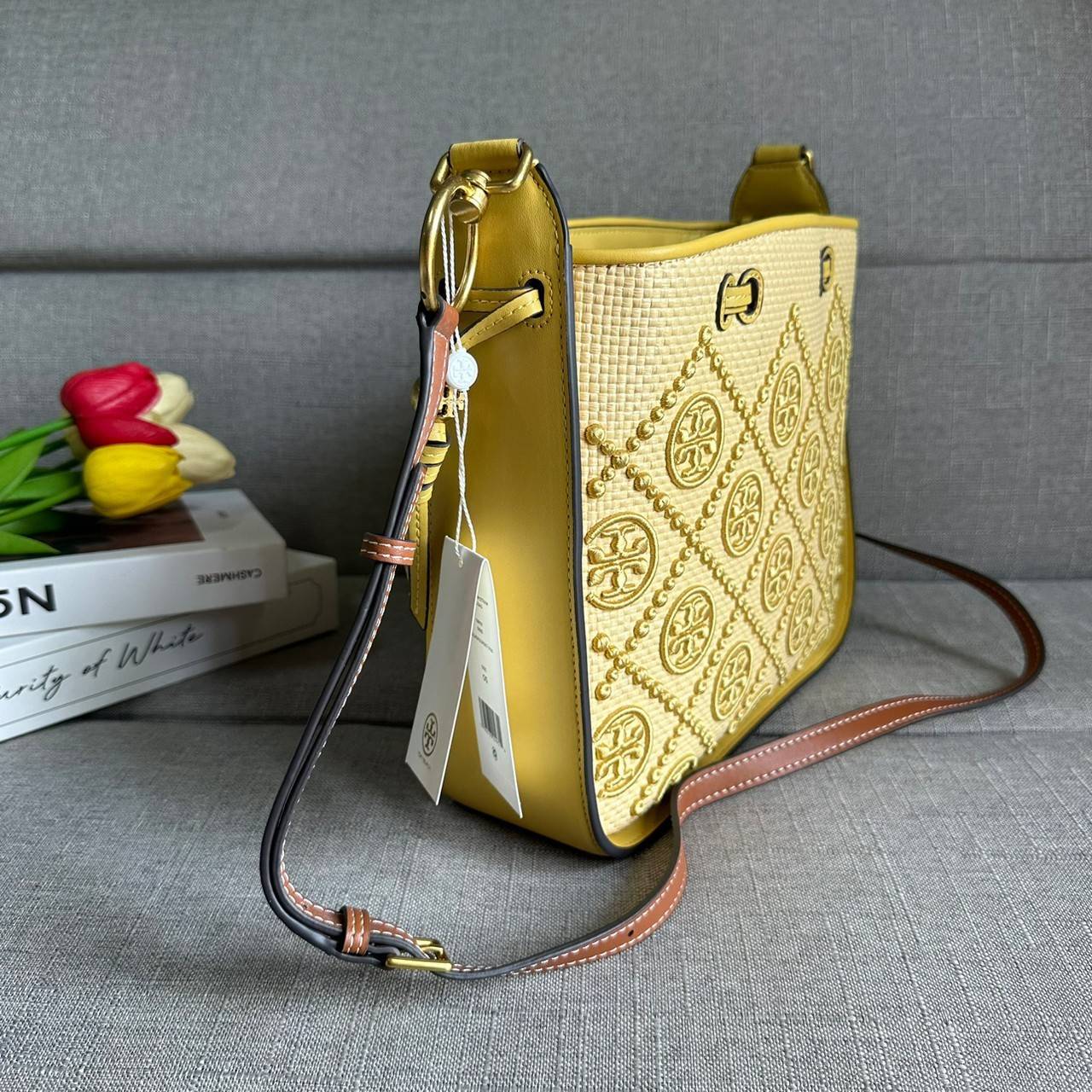 TORY BURCH T Monogram Straw Bell Bag กระเป๋าสะพายข้างรุ่นคลาสสิกที่ได้แรงบันดาลใจจากการควิลท์แบบดั้งเดิมของเพนซิลเวเนีย คอลเลกชันบ่งบอกถึงความมีสไตล์เหนือกาลเวลา รูปทรงเรียวโดดเด่น ปักทอลายแบรนด์อย่างสวยงาม เปิด ปิดด้วยเชือกรูด ด้านในช่องโล่งกว้าง ซับในผ้