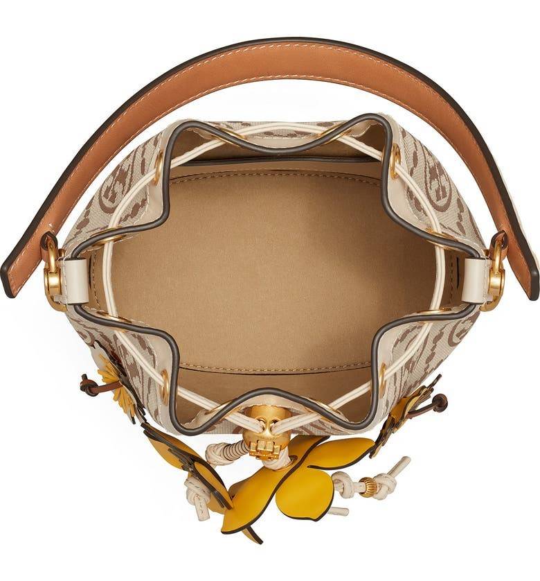 TORY BURCH T MONOGRAM FLORAL BUCKET BAG คอลเลคชั่นใหม่ พร้อมเสิร์ฟความสวยให้ถึงบ้าน!! กระเป๋าบัคเก็ตทรงยอดนิยม ดีไซน์ใหม่ล่าสุด สไตล์งานคราฟ มีลูกเล่นประดับดอกไม้กับตัวกระเป๋า และตัวรูดสาย วัสดุผ้า jacquard ตัดสลับหนังแท้ หูจับและขอบกระเป๋าตกแต่งลายสานสวย