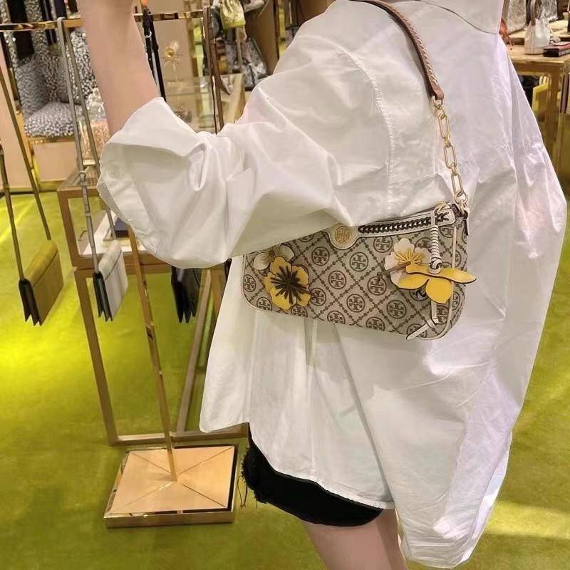 Tory Burch T Monogram Braided Floral Studio Shoulder Bag กระเป๋าถือหรือสะพายไหล่ลาย Monogramวัสดุผ้าJacquard+หนังแท้ ตัดเย็บอย่างปราณีต ผสานงานแกะสลักหนังสุดวิจิตร ประดับตกแต่งด้วยดอกไม้เพิ่มความหรู เป็นกระเป๋าดอกไม้ของฤดูกาลนี้ที่เพิ่มความซับซ้อนและแสนหว