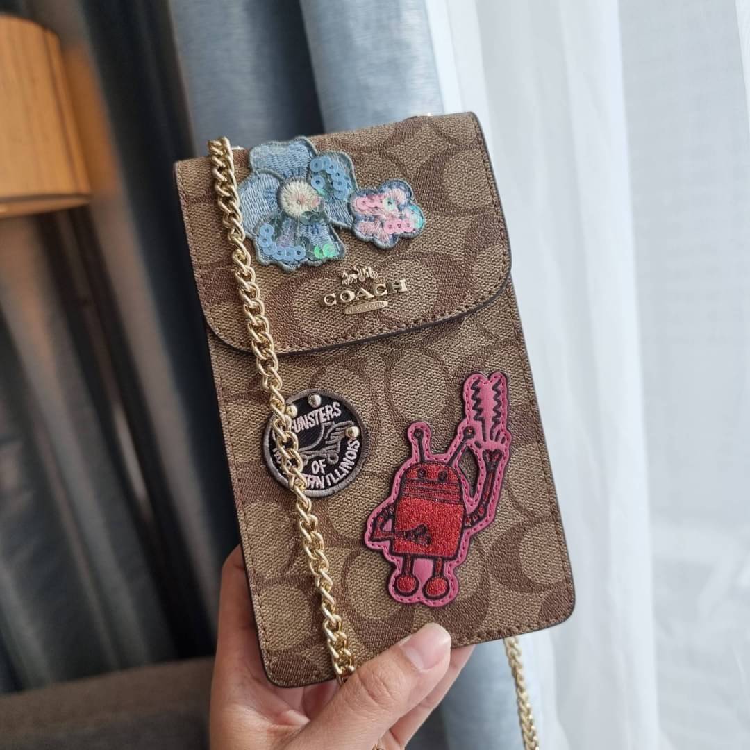 COACH NORTH/SOUTH PHONE CROSSBODY IN SIGNATURE CANVAS F55636 F39955 สุดคลาสสิคกับกระเป๋าสะพายเอนกประสงค์ Case phone ใส่โทรศัพท์มือถือได้ทุกรุ่น ดีไซน์ลายเอกลักษณ์ วัสดุหนังแคนวาสเคลือบลาย ฝาและภายในเป็นหนังสังเคราะห์เรียบ เปิด-ปิดด้วยกระดุม สายสะพายยาวประ