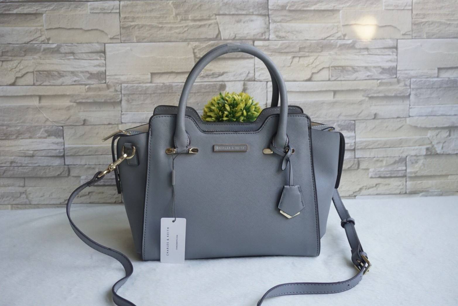 CHARLES & KEITH TRAPEZE TOP HANDLE BAG กระเป๋าสะพาย/ถือ วัสดุหนัง saffiano ใช้งานง่าย ทนมากๆค่ะ ด้านหน้ามีโลโก้แบรนด์ อะไหล่สีทองหรู มีหมุดรองฐาน 4 มุม เปิดปิดด้วยซิป ด้านในจุของมากๆ ค่ะ สายสะพายยาวถอดและปรับสายได้ 5 ระดับ สวยคุ้มมากๆใบนี้ สาวๆต้องมีค๊า