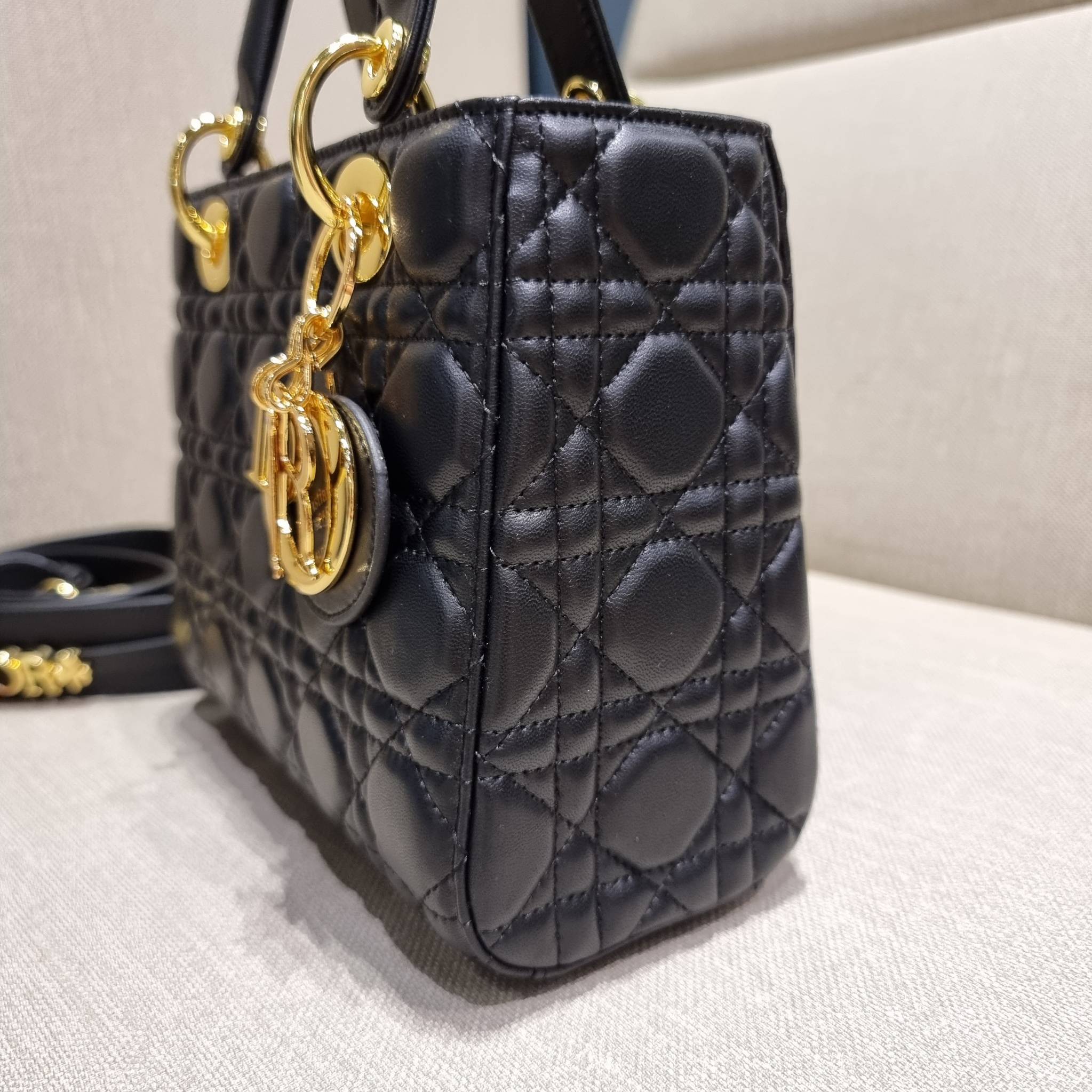 DIOR CD LADY BAG กระเป๋าสะพายข้างพรีเมี่ยมกิ๊ฟสุดฮอต ดีไซน์เรียบง่าย แต่แฝงไปด้วยความหรูหรา ทรงกล่องคลาสสิค โดดเด่นด้วยพวงกุญแจอะไหล่สีทอง วัสดุหนังแท้ มีหูจับในตัวและสายครอสบอดี้สุดเลิศ ที่มาพร้อมอะไหล่ฟอนท์สีทองเรียงร้อยในสายหนัง แต่งเติมดีเทลอัพราคาไปอ