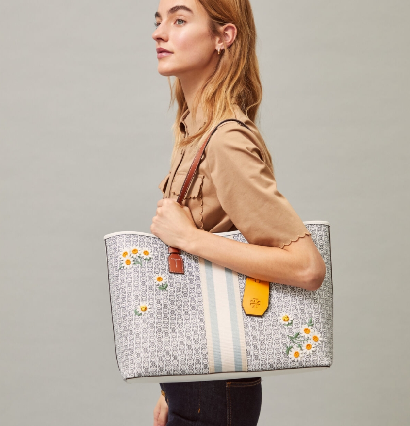 Tory burch Gemini Canvas Applique Small Tote Bag กระเป๋าสุดปังจากทอรี่ เบริช์(Tory Burch) อย่างเจมิไนลิงค์ ในทรง tote bag มีเอกลักษณ์โดดเด่นที่ลายทางตรงกลาง มีการพิมพ์แพทเทิรน์โซ่แบบเรียบหรู เพิ่มความน่ารักจากดอกเดรซี่ที่ถูกจัดวางให้ดูมีสีสัน มีสายสะพายให