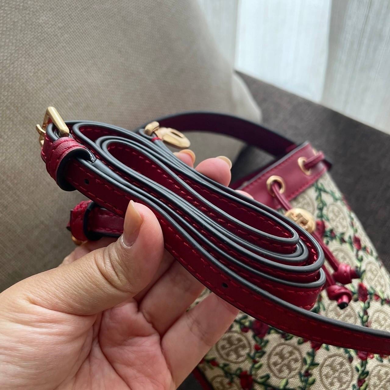 Mini : Tory Burch T Monogram Embroidered Mini Bucket Bag Hazelnut กระเป๋าทรงถังขนาดเล็ก เป็นแพทเทิร์นคลาสสิคที่ได้รับแรงบันดาลใจจากการควิลท์แบบดั้งเดิมของเพนซิลเวเนีย คอลเล็คชั่นบอกเล่าความมีสไตล์เหนือกาลเวลา ลายดอกกุหลาบสีแดงลายปักษ์ วัสดุผ้าสว๊อตซ์วินเท