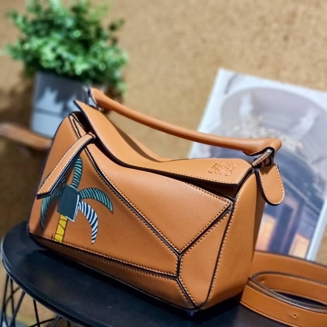 VIP 】LOEWE LA PALME PUZZLE BAG IN CLASSIC CALFSKIN คอลเลคชั่นใหม่!! กระเป๋าสะพายข้างทรงกล่อง สไตล์พัซเซิล ให้ฟีลลิ่งเหมือนตัวต่อ ดูดีได้ทุกที่แค่มีใบนี้ รอบนี้ดีไซน์พริ้นท์ลายต้นปาล์มเก๋ๆ ซัมเมอร์ยังต้องมา วัสดุหนังวัวฟอกสี เปิดใช้งานด้วยซิป ที่ภายในโล่งพ