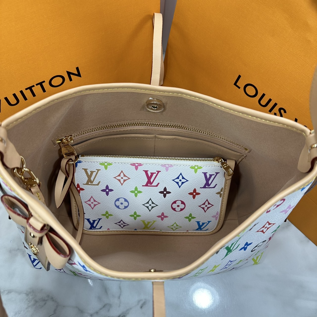 LV x TM CarryAll PM bag Murakami กระเป๋าทรงโท้ทแครี่ออลสุดคลาสสิกแต่งแต้มดีเทลเปี่ยมชีวิตชีวาจากคอลเลคชั่น LV x Murakami ด้วยลายโมโนแกรมสุดไอคอนิกเปี่ยมสีสันใหม่