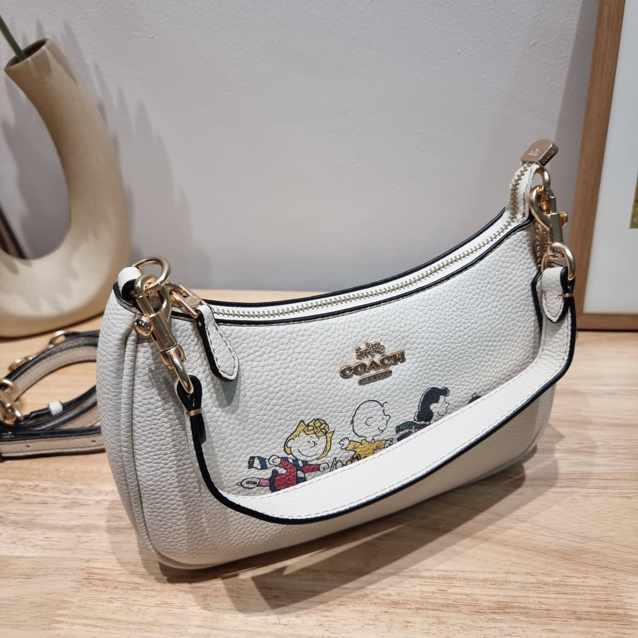 Coach X Peanuts Teri Shoulder Bag With Snoopy And Friends Motif CE861 คอลเลคชั่นสุดคิ้วท์ ไม่ให้ช้อปยังไงไหว!! กับกระเป๋าสะพายไหล่กึ่งทรงพอช พร้อมเสิร์ฟความสวยถึงบ้านไปเลยก่อนใคร แบบไม่ต้องพรีฯ ด้วยดีไซน์ลวดลายกาน์ตูนยอดฮิต มาพร้อมสายสะพาย 2 เส้น