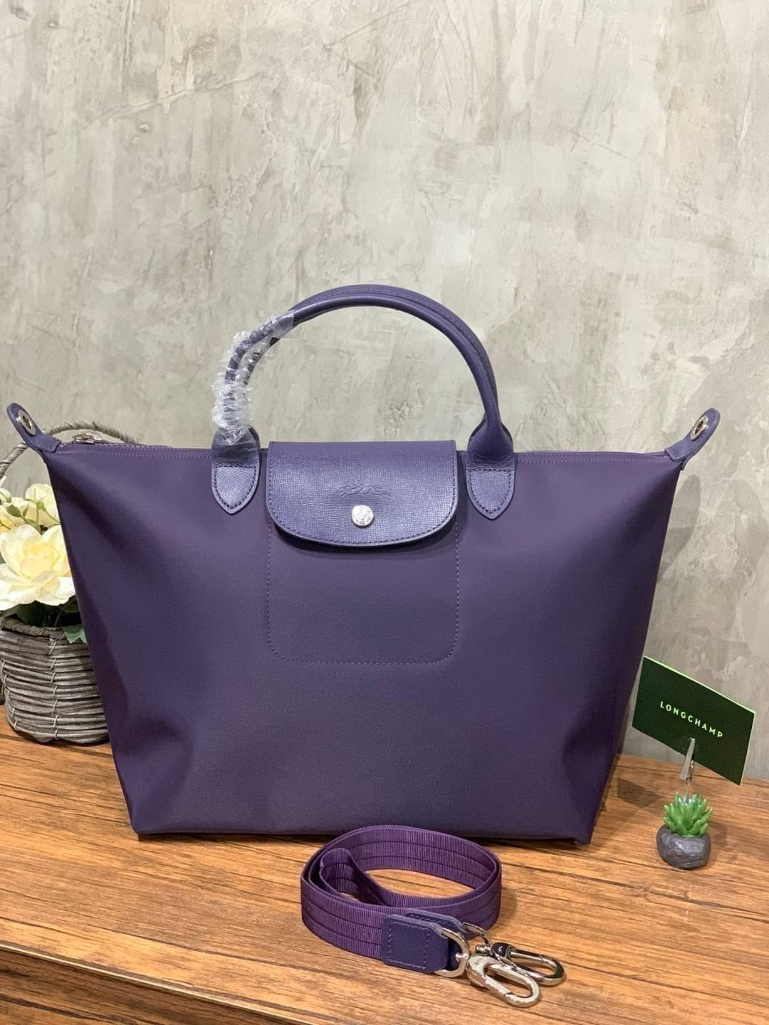 Longchamp Le Pliage Neo Size M มาพบกับกระเป๋ารุ่นยอดนิยม ที่สาวๆ ต้องมีไว้เก็บไว้สักใบ กระเป๋าโท้ทใบนี้ มาพร้อมกับสีที่มีสไตล์เรียบง่าย มีสายสะพายยาวช่วยให้คุณสามารถสะพายไหล่ได้อย่างสบาย ในขณะที่ที่ปิดแบบซิปช่วยให้คุณมั่นใจได้ว่าของด้านในมีความปลอดภัย Le 