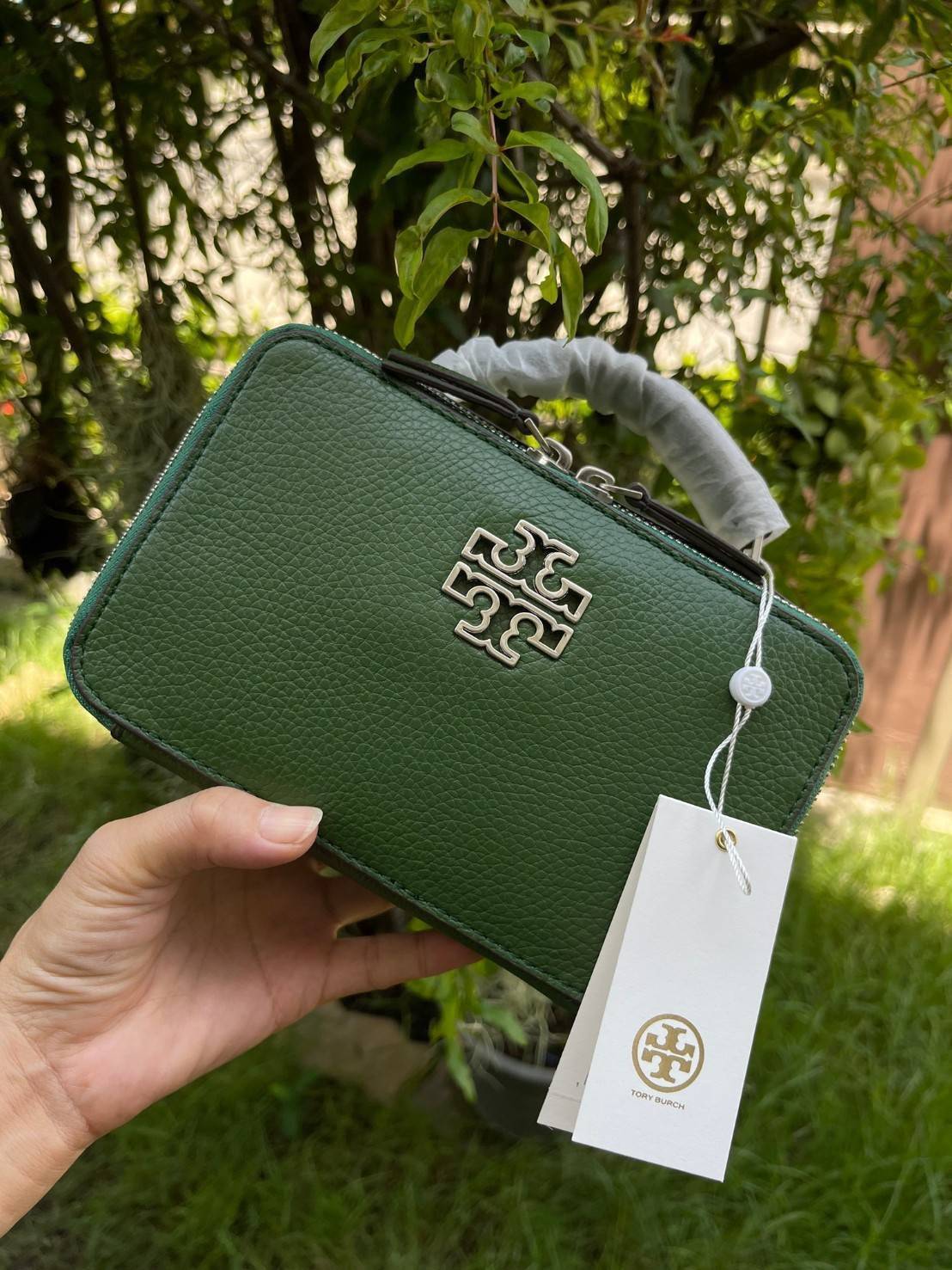 Tory burch Top Handle Case (84710) Collection ใหม่ที่เพิ่งเปิดตัวไปไม่นานจุดเด่นของรุ่นนี้คือดีไซน์ออกมาในสไตล์คลาสสิกที่มาพร้อมกับฮาร์ดแวร์ที่ทำจากวัสดุทองเหลืองและสายสะพายโซ่และหนัง ปากกระเป๋าเปิดได้กว้างแบบสองซิป รูปทรงสามารถสะพายใช้งานได้หลายโอกาส ไม่