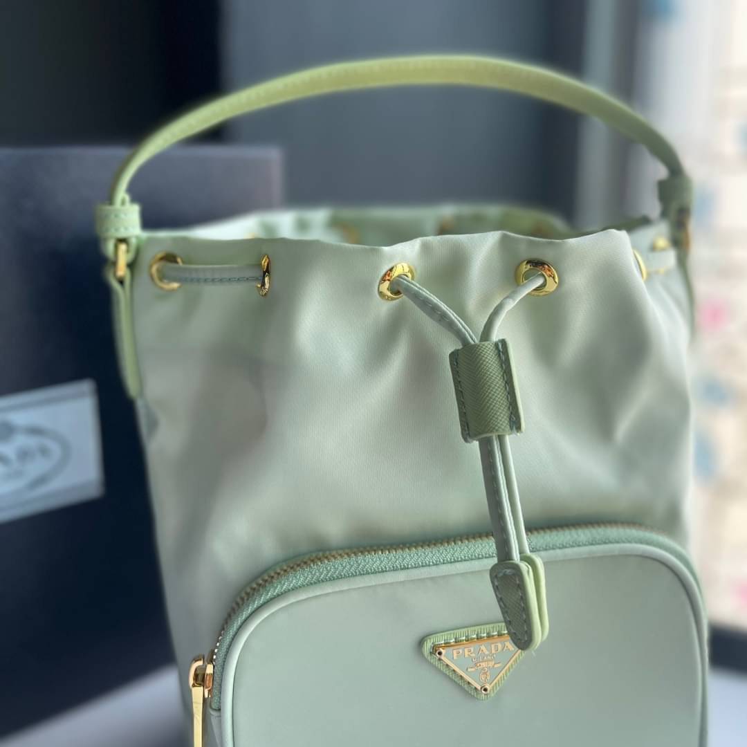 Prada Duet Re-Nylon Bucket shoulder bag / Prada Nylon bucket bag Pastel เกรดใช้สลับใบจริง ออริจินอล ใช้งานต่างประเทศได้ น้องสาวสุดสวยมาให้จับจองอีกหนึ่ง สีพาสเทลน่ารักละมุนมากๆ ค่ะ กระเป๋าสะพายข้าง ทรงขนมจีบ ไซส์มินิ ขนาดน่ารักน่าใช้มาก วัสดุขอบหนังแท้ แล