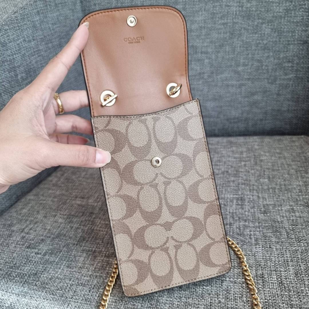 COACH NORTH/SOUTH PHONE CROSSBODY IN SIGNATURE CANVAS F55636 F39955 สุดคลาสสิคกับกระเป๋าสะพายเอนกประสงค์ Case phone ใส่โทรศัพท์มือถือได้ทุกรุ่น ดีไซน์ลายเอกลักษณ์ วัสดุหนังแคนวาสเคลือบลาย ฝาและภายในเป็นหนังสังเคราะห์เรียบ เปิด-ปิดด้วยกระดุม สายสะพายยาวประ