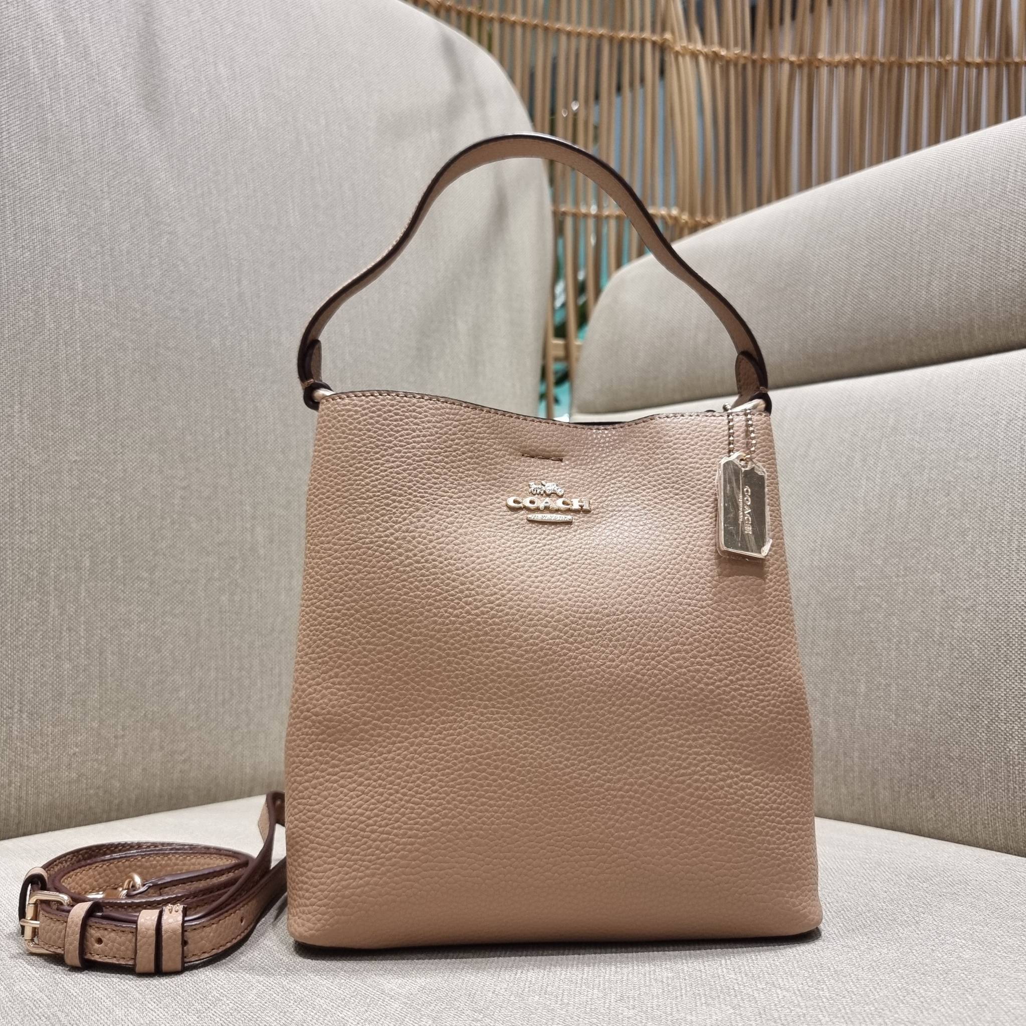 COACH 1011 SMALL TOWN BUCKET BAG รุ่นยอดนิยมใบเล็ก กระเป๋าทรงบัคเก็ต สีคลาสสิคเรียบหรู ตัดกับโลโก้สีทองดูโดดเด่น วัสดุหนัง pepble สวยคมทุกมุมจริงๆ!! เปิด-ปิดด้วยกระดุมแม่เหล็กทั้ง 2 ฝั่ง ภายในเป็นช่องโล่ง มาพร้อมสายสะพายปรับได้ตามตัว ขนาดใบนี้กำลังสวย สะพ