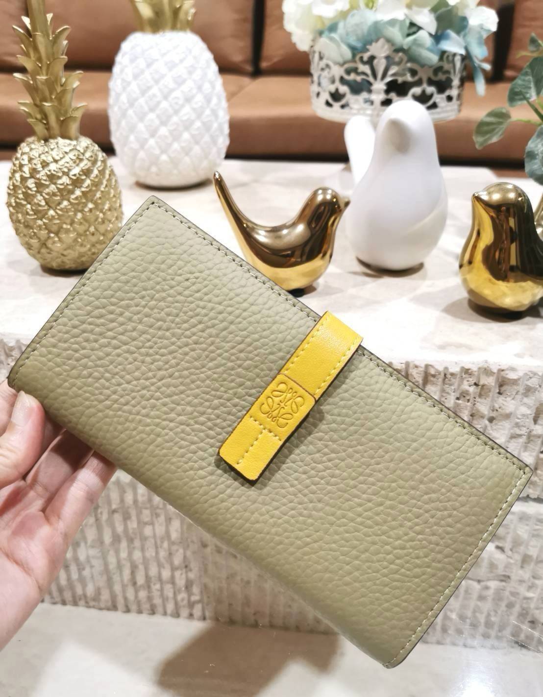LOEWE LONG WALLET BAG วัสดุหนังแท้เทคเจอร์สวยอยู่ทรงปั้มโลโก้แบรนด์ด้านหน้าเปิดปิดด้วยกระดุม ภายในมีช่องใส่ธนบัตรหลายช่อง ช่องหลักสามารถใส่มือถือได้ มีช่องซิปใส่เหรียญ ช่องใส่ธนบัตรใส่แบงก์พันได้ สวยน่าใช้ พร้อมส่งที่ไทยสุดคุ้มห้ามพลาด!