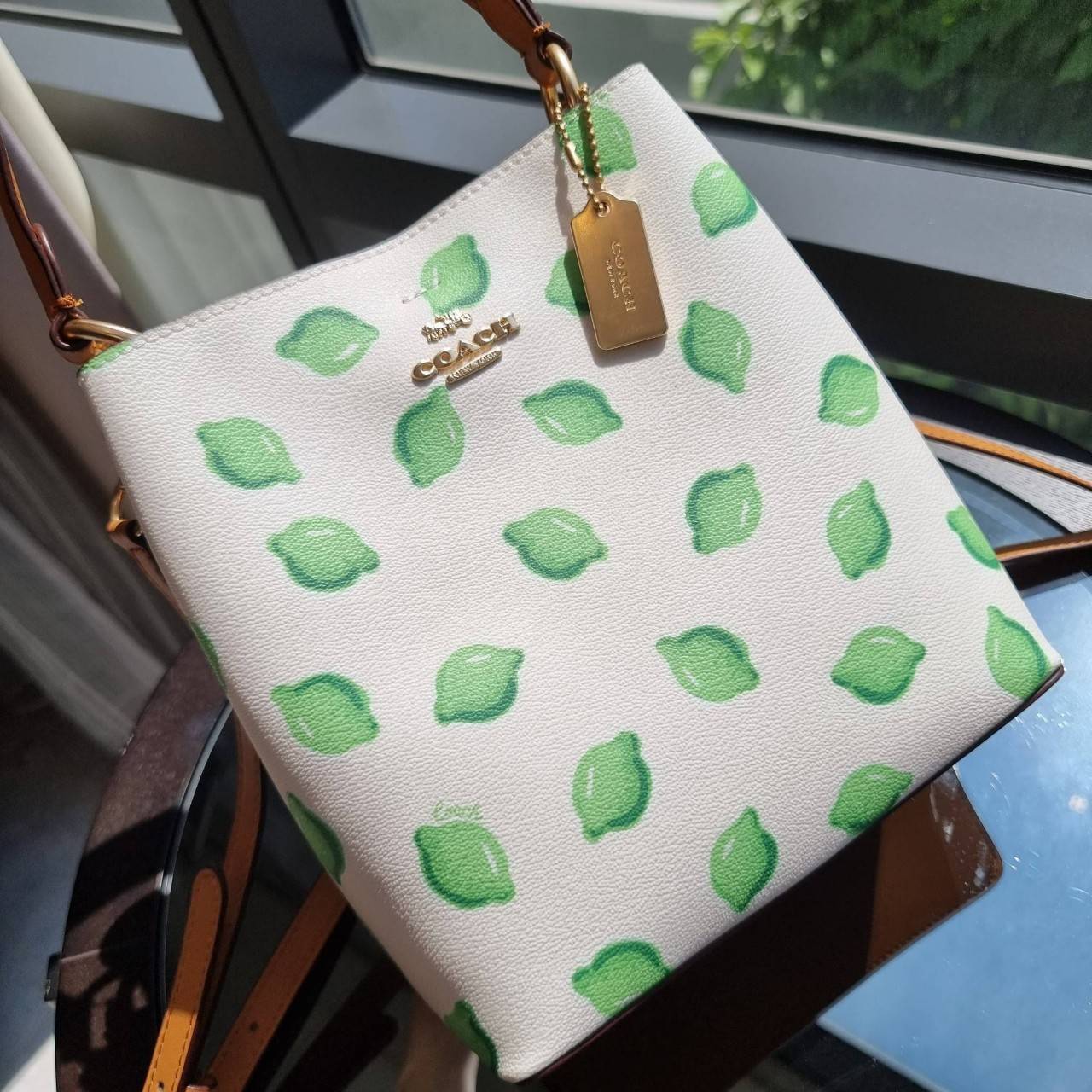 OUTTLET 】COACH 1625 SMALL TOWN BUCKET BAG WITH LIME PRINT ต้อนรับปีใหม่ด้วยความสดใส กับรุ่นยอดนิยม กระเป๋าทรงบัคเก็ตไซส์เล็ก ดีไซน์ลวดลายจี๊ดจ๊าด น่าใช้จริงจัง วัสดุหนังแคนวาสเคลือบลาย สวยคมแซ่บมากๆ เปิด-ปิดด้วยกระดุมแม่เหล็กทั้ง 2 ฝั่ง ภายในเป็นช่องโล่ง 