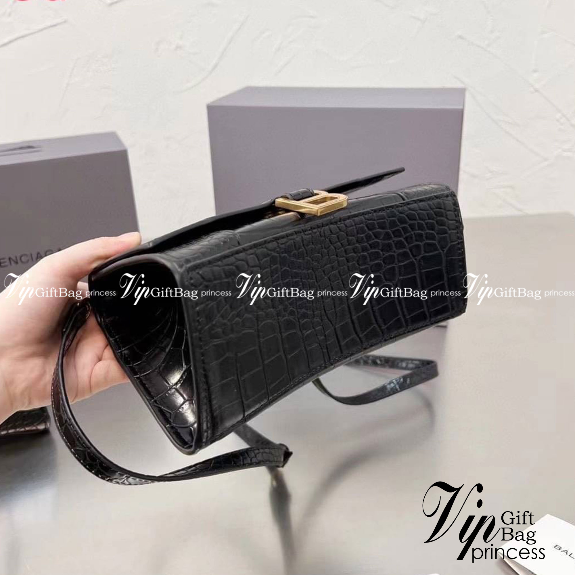 BALENCIAGA Hourglass BAG XS S / BALENCIAGA Hourglass Crocodile embossed calfskin กระเป๋าสะพายแบรนด์หรูซิกเนเจอร์ใบล่าสุด ที่มาพร้อมดีไซน์โดดเด่น มีความโฉบเฉี่ยว โค้งมนเหมือนพระจันทร์เสี้ยว เพิ่มความโดดเด่นสะดุดตาด้วยการตกแต่งอักษร B เมทัลลิก ที่เป็นเอกลัก