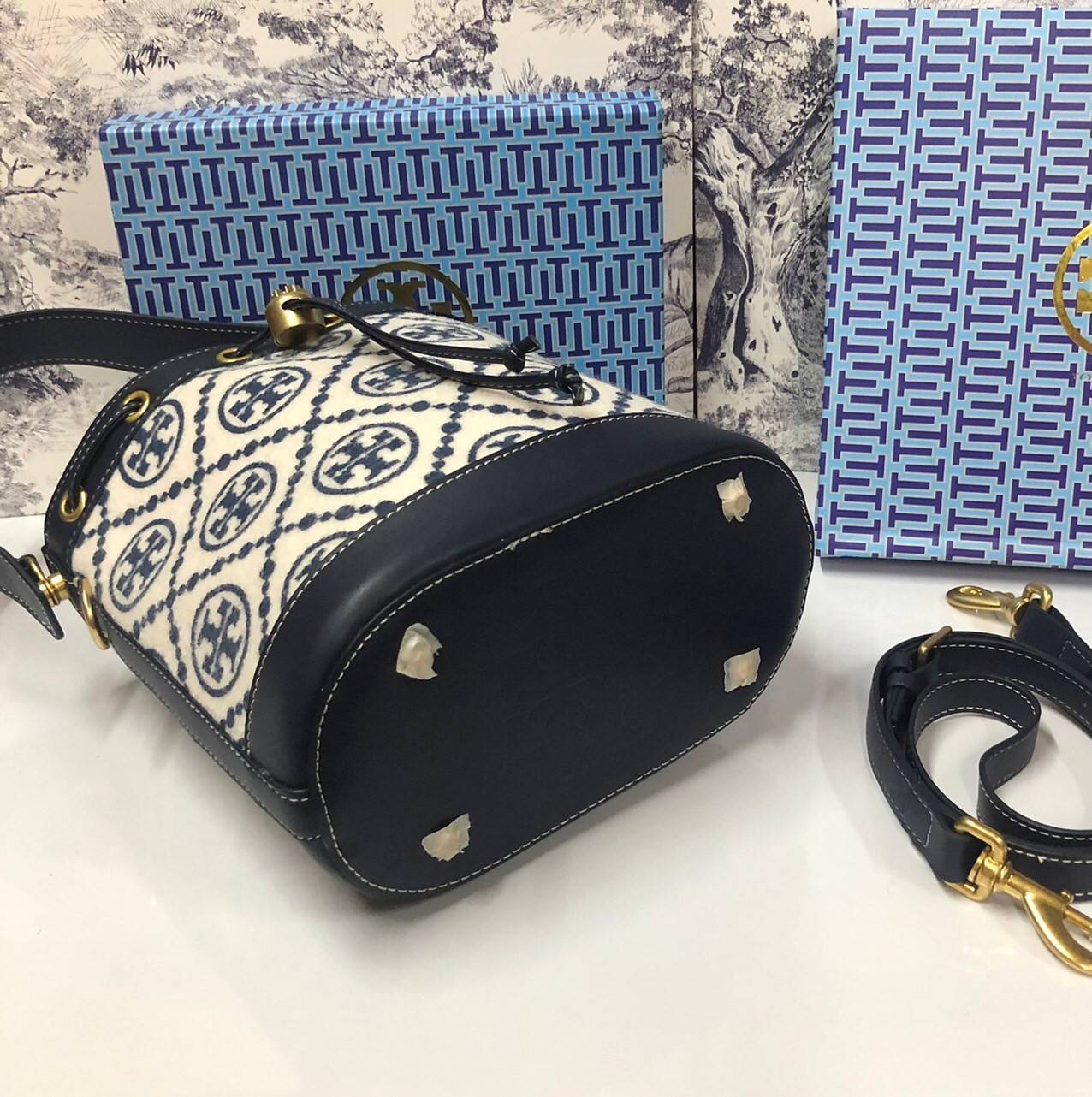 Medium : Tory Burch T Monogram Chenille Bucket Bag เปิดตัวอีกหนึ่งรุ่นกับกระเป๋าลาย T MONOGRAM รุ่นใหม่ล่าสุดจาก TORY BURCH พลาดไม่ได้กับโลโก้สุดคลาสสิก ลวดลาย T Monogram คือวัสดุ chenille หรือที่เรียกว่า ด้านไหมกำมะหยี่ มารังสรรค์ลงบนกระเป๋าBucketใบนี้ เ