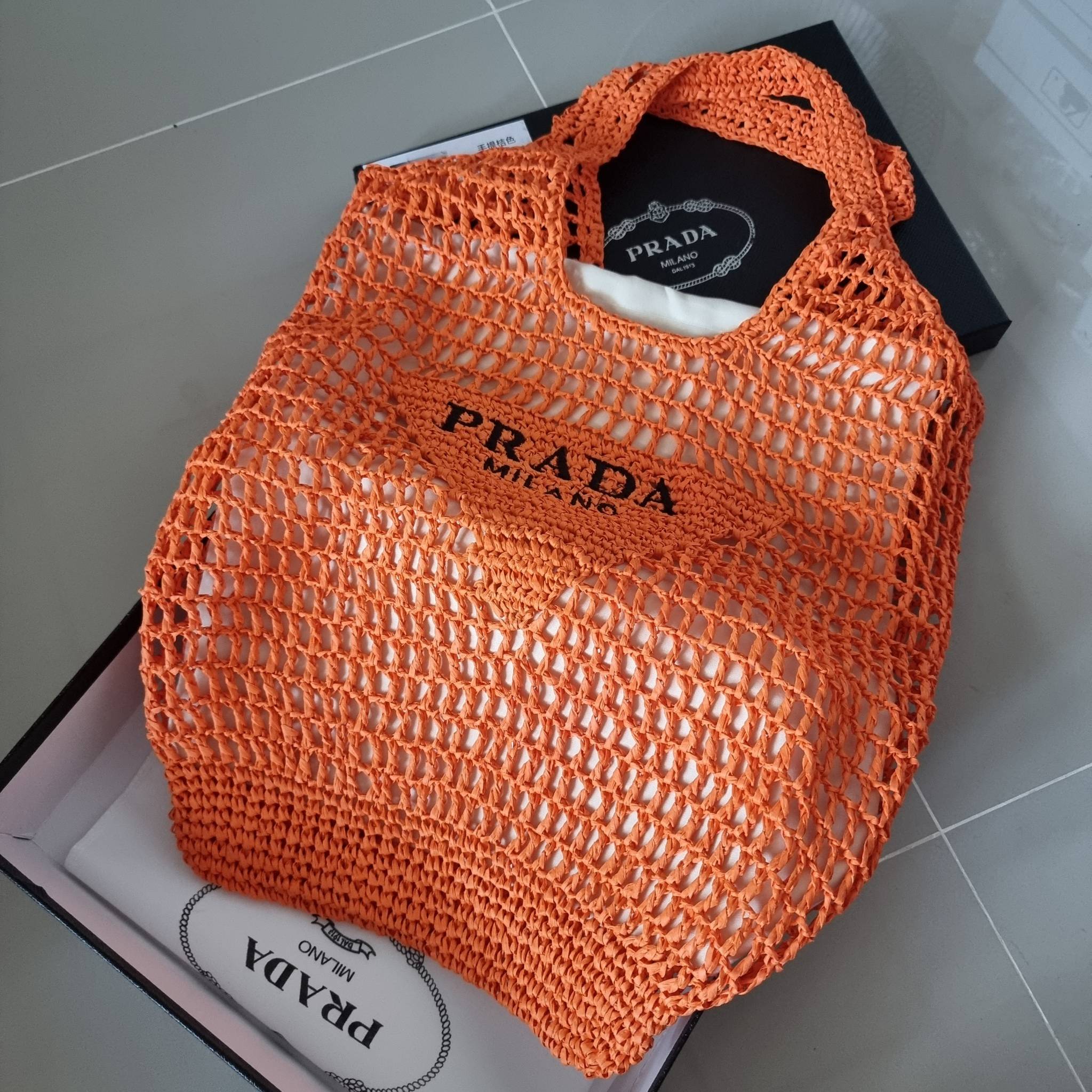 PRADA RAFFIA TOTE BAG สวยไม่ซ้ำใคร สไตล์บีช เหมาะมากกับการสะพายไปเที่ยวทะเล หรือจะใช้ในวันสบายๆก็ตอบโจทย์ กับกระเป๋าสะพายสานใบใหญ่ ตัวกระเป๋าเป็นวัสดุสังเคราห์จากธรรมชาติ สานทอเต็มใบออกมาเป็นลวดลายสวยงาม