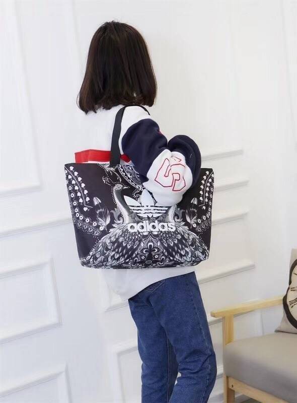 Adidas Original Large Tote Bag กระเป๋าสะพายทรง Tote หรือทรง shopping ใบใหญ่จาก Adidas Factory Outlet วัสดุ Nylon & Polyester 100% เนื้อนิ่มคุณภาพดี น้ำหนักเบาใบใหญ่จุได้เยอะ เปิดปิดด้วยซิปเดียวด้านบน หัวซิปปั้มโลโก้ ภายในมีช่องซิป แยกเก็บของสำคัญ และช่องใ