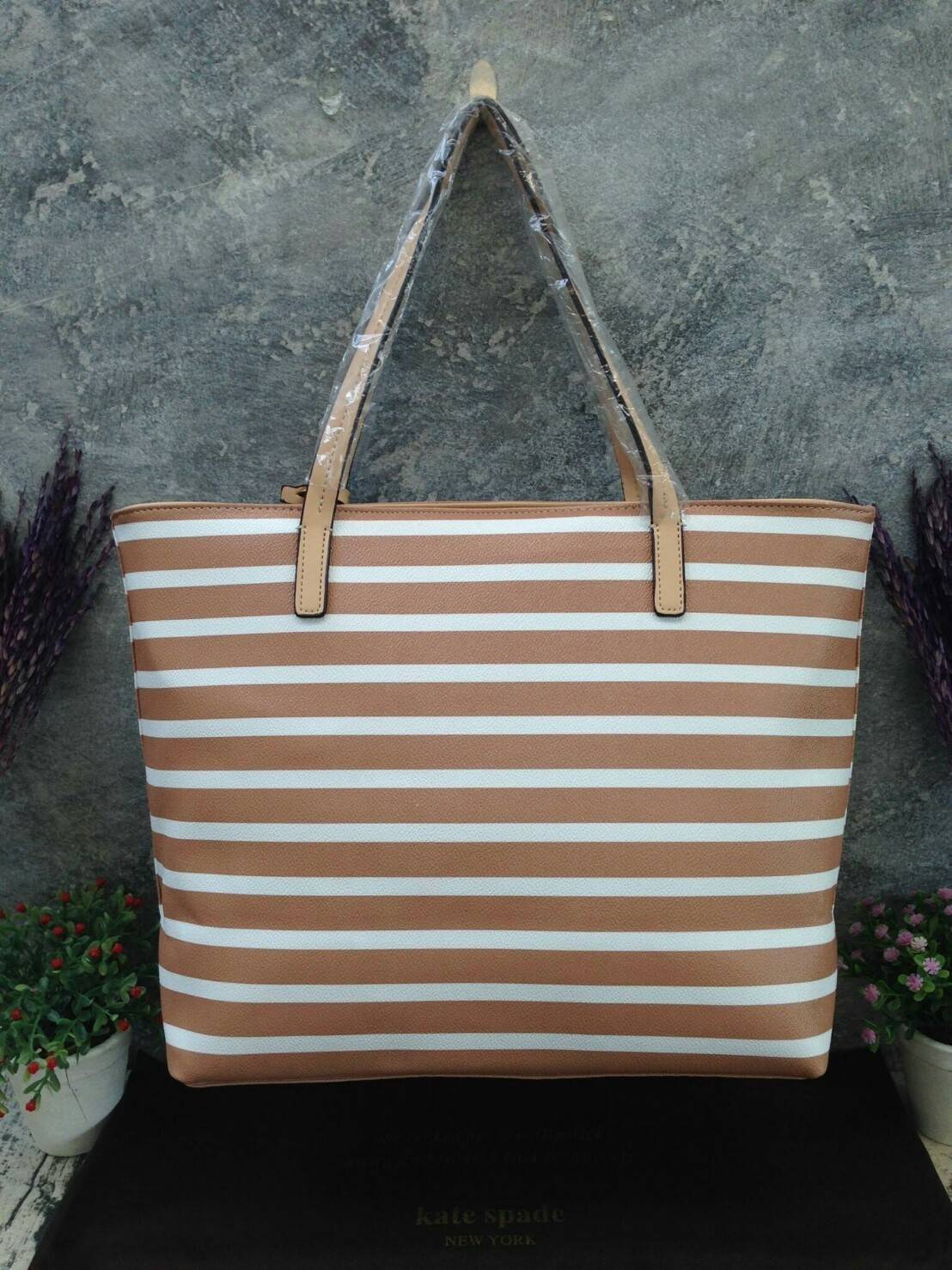 KATE SPADE HYDE LANE STRIPED RILEY LEATHER TOTE BAG กระเป๋าสะพายทรง Tote Bag หนังสวยอยู่ทรง โดดเด่นที่สีทูโทนลายทางห้อยโลโก้ TAGcที่หูกระเป๋า ด้านหน้าประดับโลโก้ มี1ช่องใส่ของ ภายในมีช่องซิป และช่องใส่มือถือ กว้างและจุ ใส่ ipad notebook เอกสาร A4 กระเป๋าส