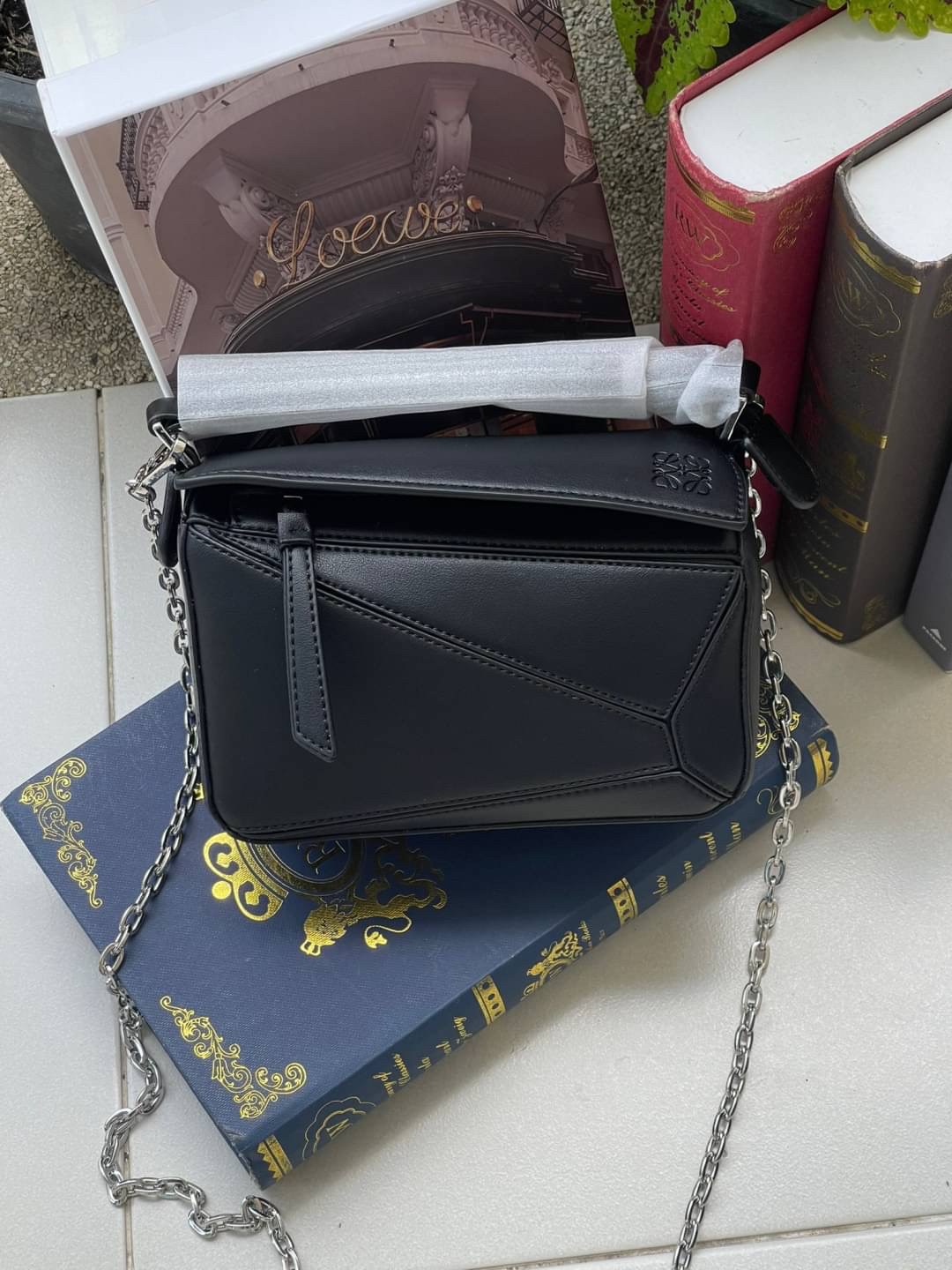 Loewe Nano Puzzle bag in classic โลเอเว่ (LOEWE) อีกหนึ่งกระเป๋าแบรนด์ดังจากสเปน ภายใต้คอลเลคชั่นใหม่อันร่วมสมัยของแบรนด์ มีความเป็นคลาสสิคและโมเดิร์นทันสมัย กระเป๋าที่มาในรูปแบบสี่เหลี่ยมผืนผ้า ที่สามารถใช้งานได้ทั้งแบบหูหิ้ว และแบบ Crossbody ด้านในมีช่อ