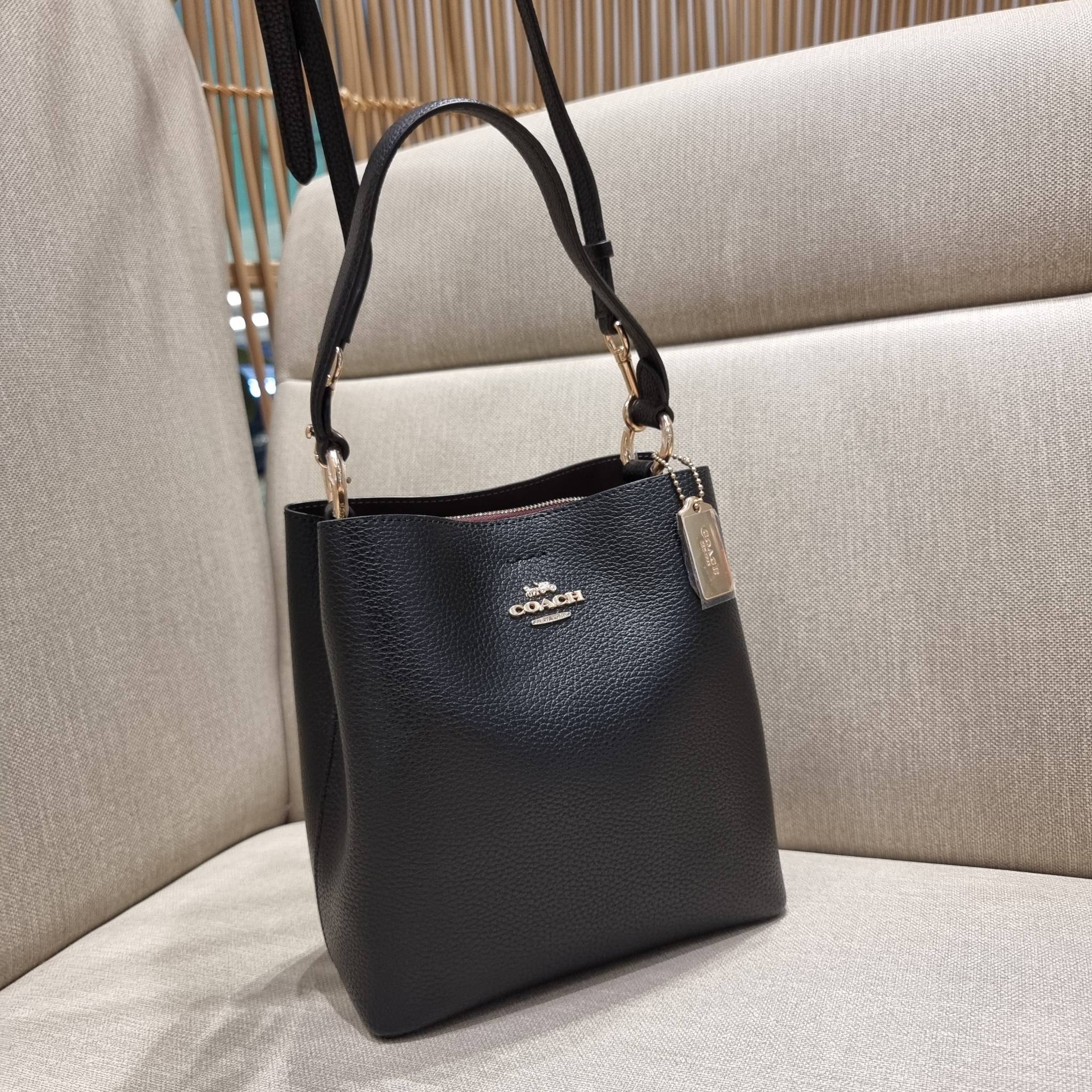 COACH 1011 SMALL TOWN BUCKET BAG รุ่นยอดนิยมใบเล็ก กระเป๋าทรงบัคเก็ต สีคลาสสิคเรียบหรู ตัดกับโลโก้สีทองดูโดดเด่น วัสดุหนัง pepble สวยคมทุกมุมจริงๆ!! เปิด-ปิดด้วยกระดุมแม่เหล็กทั้ง 2 ฝั่ง ภายในเป็นช่องโล่ง มาพร้อมสายสะพายปรับได้ตามตัว ขนาดใบนี้กำลังสวย สะพ