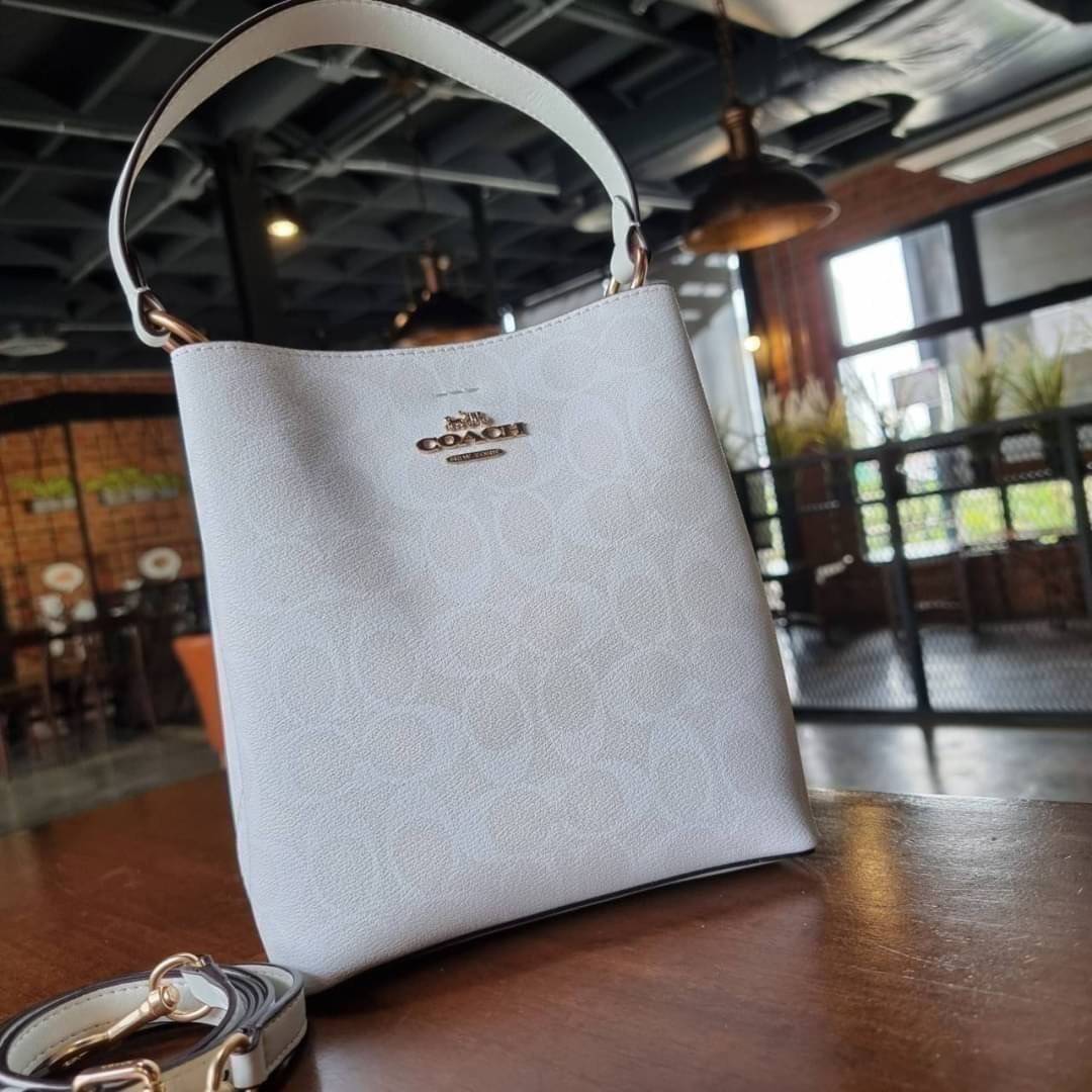 COACH 2312 SMALL TOWN BUCKET BAG IN SIGNATURE CANVAS รุ่นยอดนิยมใบเล็กมาครบสีแล้วจ้า กระเป๋าทรงบัคเก็ต สีผู้ดี๊ผู้ดี ตัวกระเป๋าดีไซน์คลาสสิคลายซี ดูโดดเด่น วัสดุหนังแคนวาสเคลือบลาย สวยคมทุกมุมจริงๆ!! เปิด-ปิดด้วยกระดุมแม่เหล็กทั้ง 2 ฝั่ง ภายในเป็นช่องโล่ง