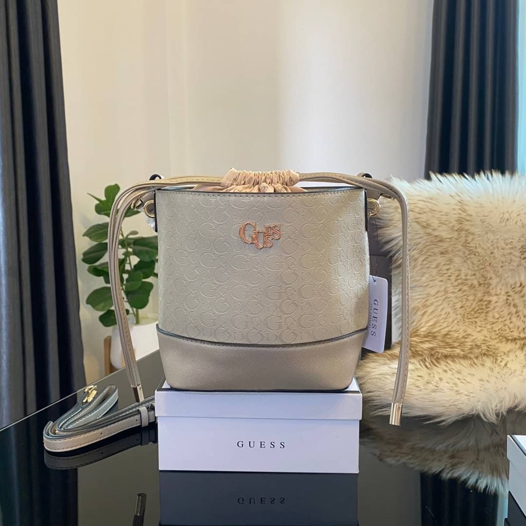 Guess Agata Bucket Handbag กระเป๋ารุ่นใหม่ล่าสุดทรงถังสุดน่ารัก พิมพ์ลายรอบใบ วัสดุ Saffiano PU คุณภาพดี นิ่ม น้ำหนักเบา ด้านหน้าประดับด้วยโลโก้แบรนด์สวยโดดเด่น เปิด-ปิดด้วยเชือกหนังใช้หูรูดปลายเชือกประดับอะไหล่ทองสะดวกใช้ ด้านในโล่งกว้างมีช่องเล็กสำหรับใ