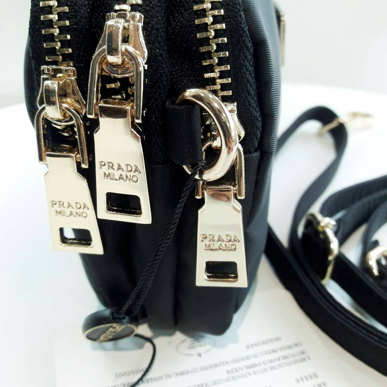 งานพรีเมี่ยมกิ้ฟ จากเคาเตอร์ต่างประเทศ จากแบรนด์ PRADA กับรุ่นขายดี ที่รอคอย Prada 3 zip nylon crossbody bag เป็นกระเป๋าใบเล็ก มีด้วยกันถึง3ช่องใส่ของ ซึ่งเหมาะกับผู้หญิงอย่างเรามาก สามารถแยกของที่จะใส่ได้เลย ตัวกระเป๋าอะไหล่สีทอง ขนาดกะทัดรัด สามารถใส่ I