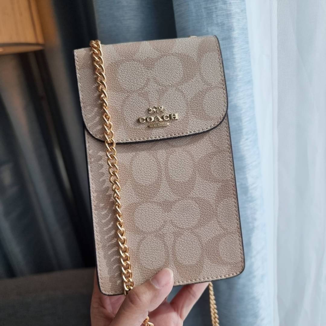 COACH NORTH/SOUTH PHONE CROSSBODY IN SIGNATURE CANVAS F55636 F39955 สุดคลาสสิคกับกระเป๋าสะพายเอนกประสงค์ Case phone ใส่โทรศัพท์มือถือได้ทุกรุ่น ดีไซน์ลายเอกลักษณ์ วัสดุหนังแคนวาสเคลือบลาย ฝาและภายในเป็นหนังสังเคราะห์เรียบ เปิด-ปิดด้วยกระดุม สายสะพายยาวประ