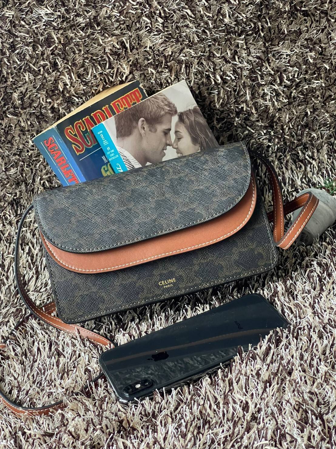 CELINE WALLET ON STRAP IN TRIOMPHE CANVAS กระเป๋าสะพายไหล่สุดเก๋ใบนี้ผลิตจากผ้าใบเคลือบอย่างดีพร้อมขอบหนังสีน้ำตาล กระเป๋ามีสายสะพายหนังสีน้ำตาลพร้อมฮาร์ดแวร์สีทอง ถอดสายออกเพื่อเป็นกระเป๋าถือทรงคลัชท์เปลี่ยนลุคช์ ลวดลายtriomphe ความเป็นแบรนด์ CELINE ได้อ