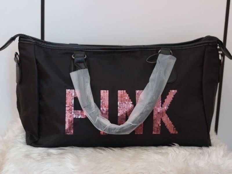 Victorias Secret PINK กระเป๋าสไตล์กระเป๋าเดินทาง หรือสะพายไปเล่นฟิตเนส ด้านหน้าจะมีตัวอักษร PINK เลื่อมสีชมพู เปิดปิดด้วยซิป ภายในมีช่องใหญ่ จุของได้เยอะ มีช่องใส่โทรศัพท์หรือของจุกจิก สามารถใส่เสื้อผ้าได้หลายชุด สายสะพายปรับระดับได้ และมีที่วางบ่าให้ด้วย