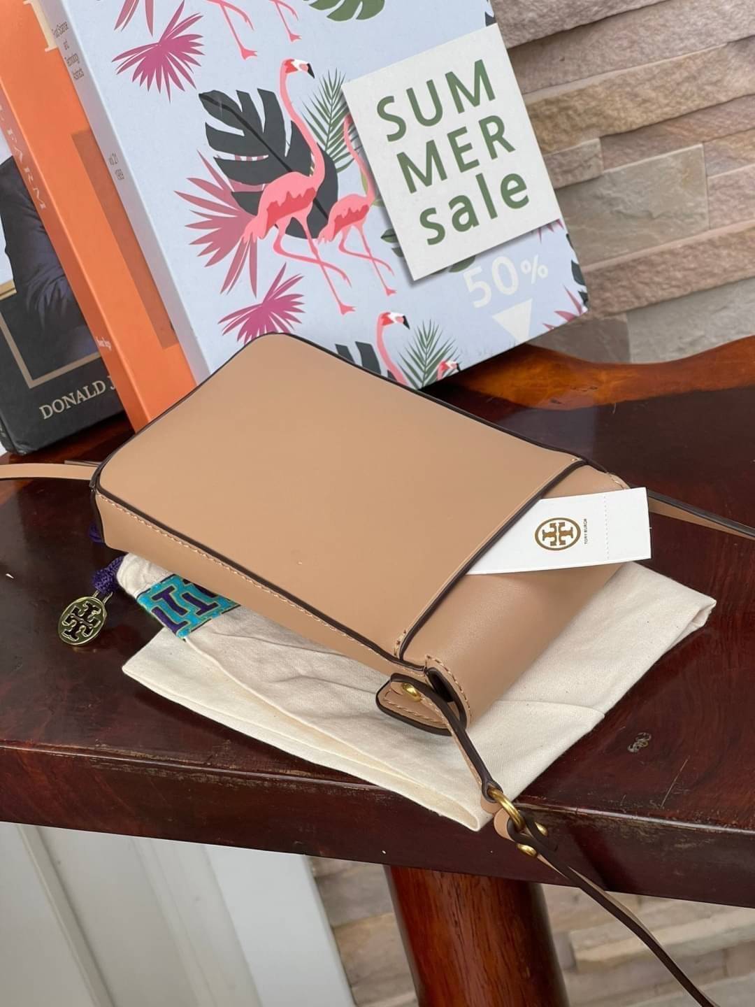 TORY BURCH MILLER METAL PHONE CROSSBODY อีกหนึ่งกระเป๋าใส่มือถือรุ่นฮิตที่เชื่อว่าหลาย ๆ คนต้องเคยเห็นผ่าน ๆ ตามาอย่างแน่นอน กับแบรนด์ Tory Burch ดีไซน์กระเป๋าทรงฝาพับแม่เหล็กใช้งานง่าย มาพร้อมดีเทล Logo แบรนด์โดดเด่นสีทองตัดกับหนังแกะสีดำ ดูหรูดูแพง! แต่