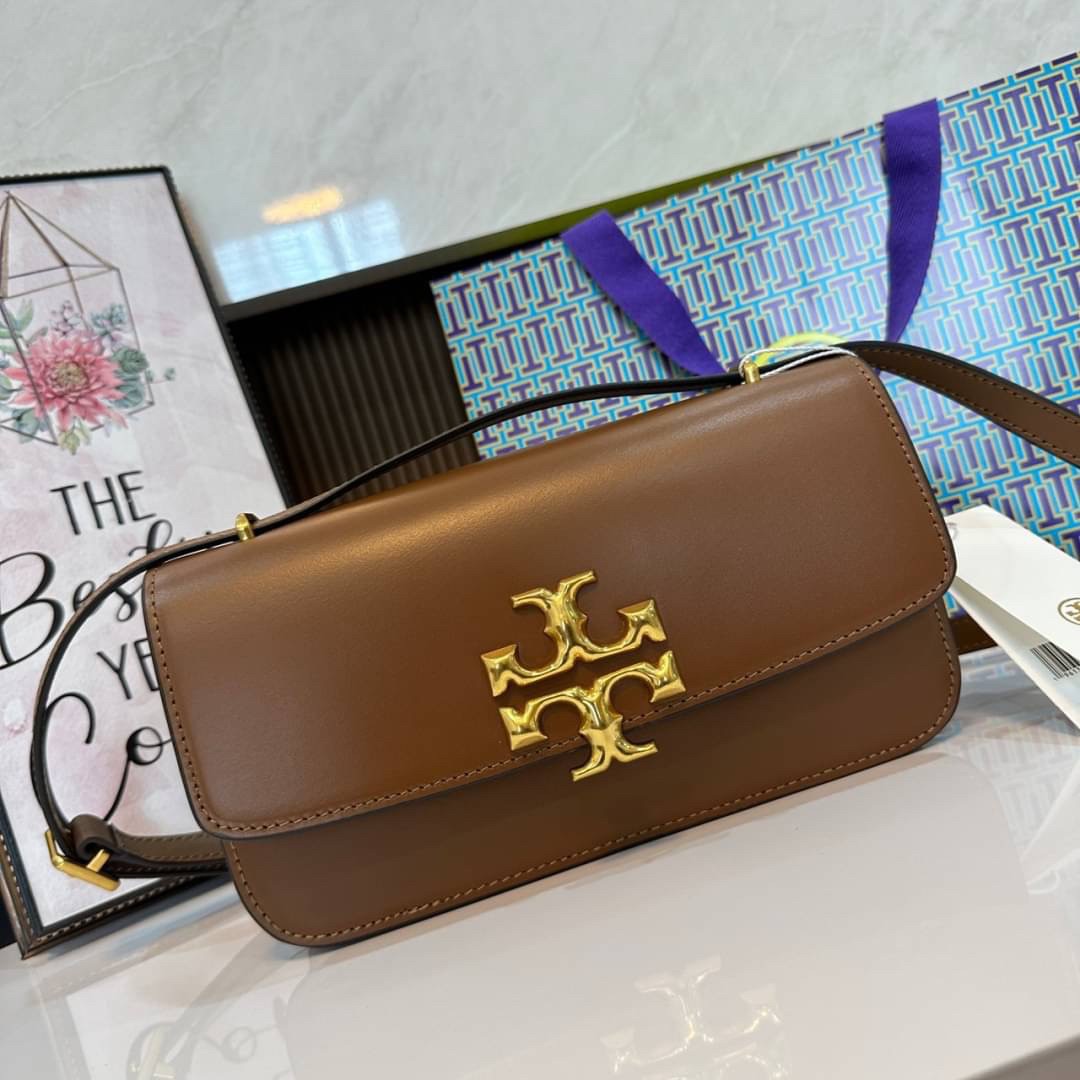 TORY BURCH ELEANOR SMALL LONG CONVERTIBLE SHOULDER กระเป๋าสะพายทรงยาว E/W Eleanor Convertible สูดหรู ดูแพง หนังแท้ เรียบสวยหรู โดดเด่นด้วยป้ายโลโก้สีทอง ลาย Double T อันเป็นเอกลักษณ์ ภายในช่องโล่งกว้างสามารถใส่โทรศัพท์ได้ทุกรุ่น สามารถใส่กระเป๋าสตางค์ใบยา