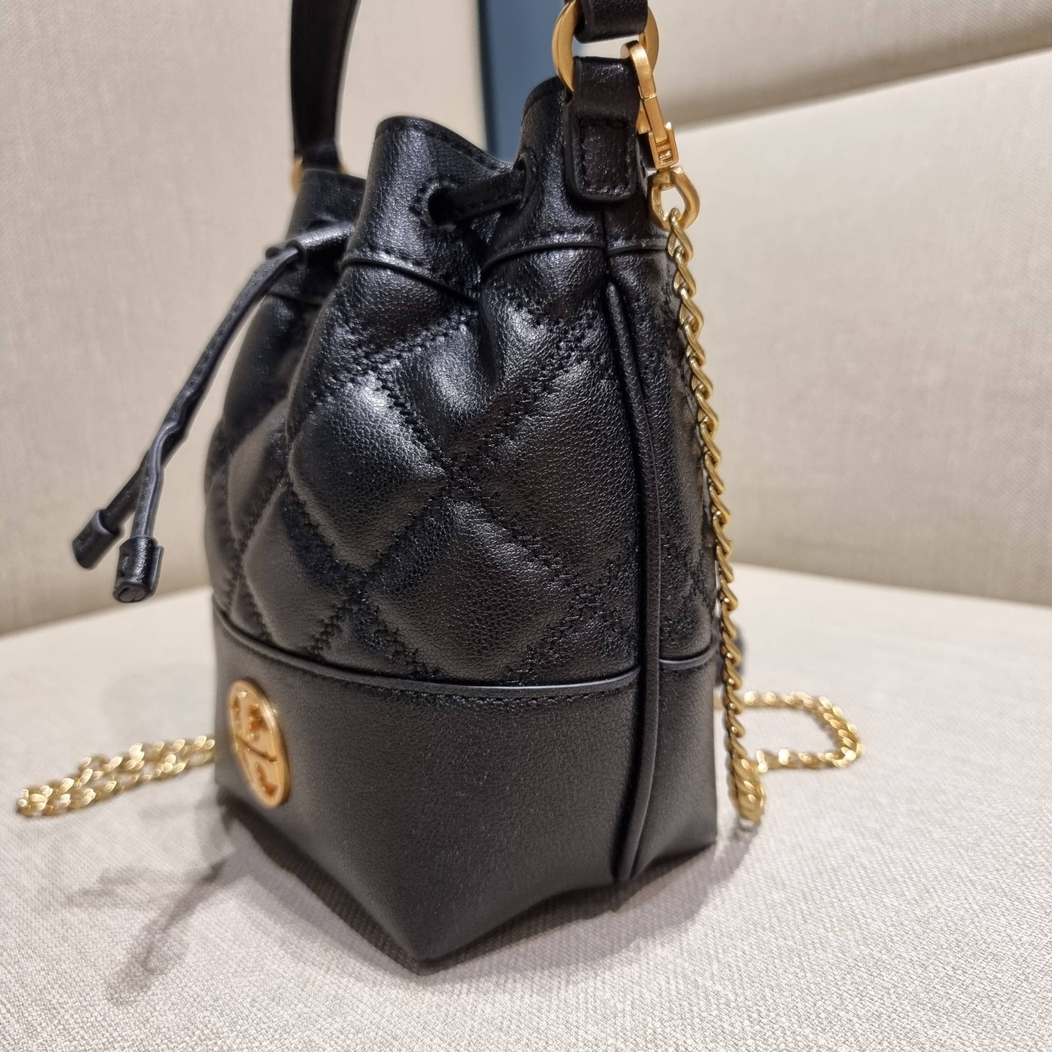 TORY BURCH WILLA MINI BUCKET BAG NEW ARRIVAL สุดปัง กระเป๋าสะพายทรงบัคเก็ต สวยผู้ดี โดดเด่นด้วยโลโก้สีทองดูหรู อัพลุคผู้ดี๊ผู้ดี วัสดุหนังแท้ ดีไซน์บุนวม เส้นคมดีเทลหรู เปิด-ปิดหนังรูดปากกระเป๋า มีหูหิ้วในตัว คล้องแขนเก๋ๆ ภายในเป็นช่องโล่ง มีช่องย่อย ใส่ข