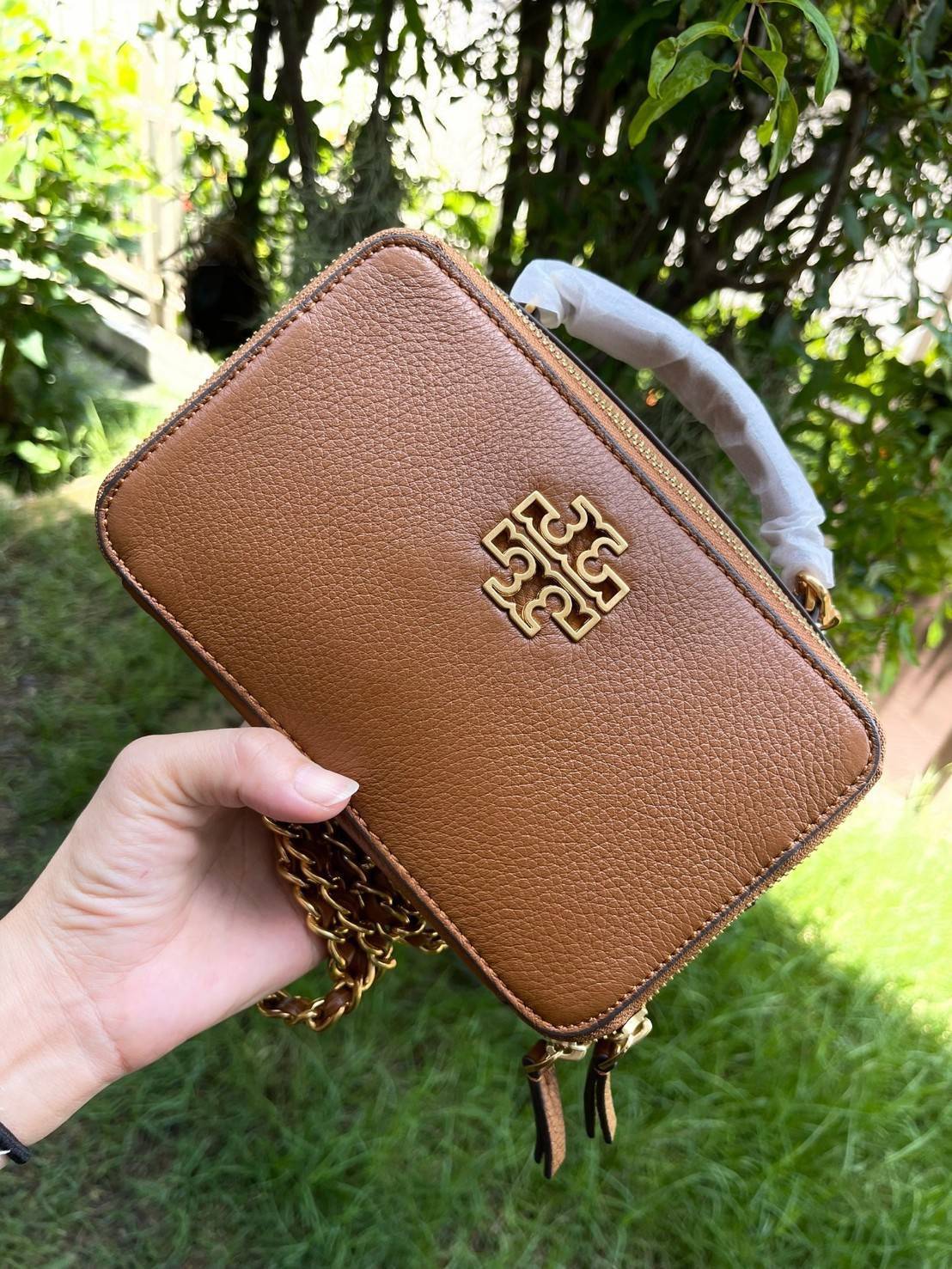 Tory burch Top Handle Case (84710) Collection ใหม่ที่เพิ่งเปิดตัวไปไม่นานจุดเด่นของรุ่นนี้คือดีไซน์ออกมาในสไตล์คลาสสิกที่มาพร้อมกับฮาร์ดแวร์ที่ทำจากวัสดุทองเหลืองและสายสะพายโซ่และหนัง ปากกระเป๋าเปิดได้กว้างแบบสองซิป รูปทรงสามารถสะพายใช้งานได้หลายโอกาส ไม่