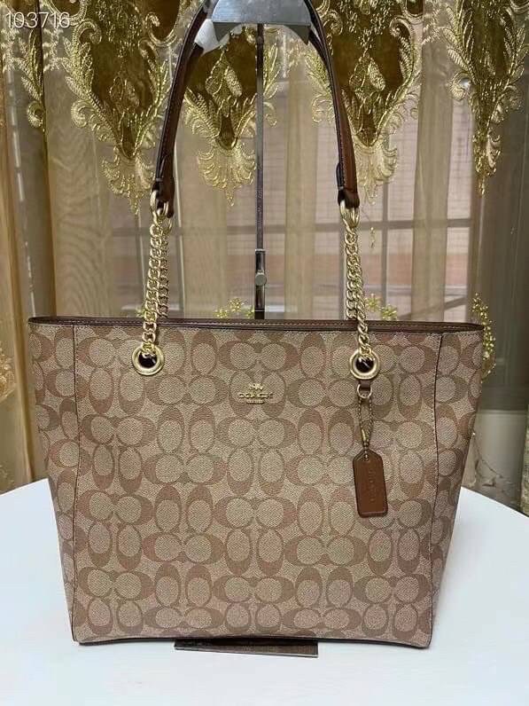 COACH Tote in Signature Canvas Bag กระเป๋าสะพายทรงช้อปปิ้ง สายกระเป๋าเป็นหนังสลับโซ่ทองสวยงาม เพิ่มความหรูหรา ภายในโล่งกว้างใส่ของได้เยอะมาก วัสดุ Canvas เคลือบลายซิกเนเจอร์และหนัง พร้อมซิปกลางเก็บของได้มิดชิดเลยค่ะ มี 3 สี น้ำตาล ดำ ขาว