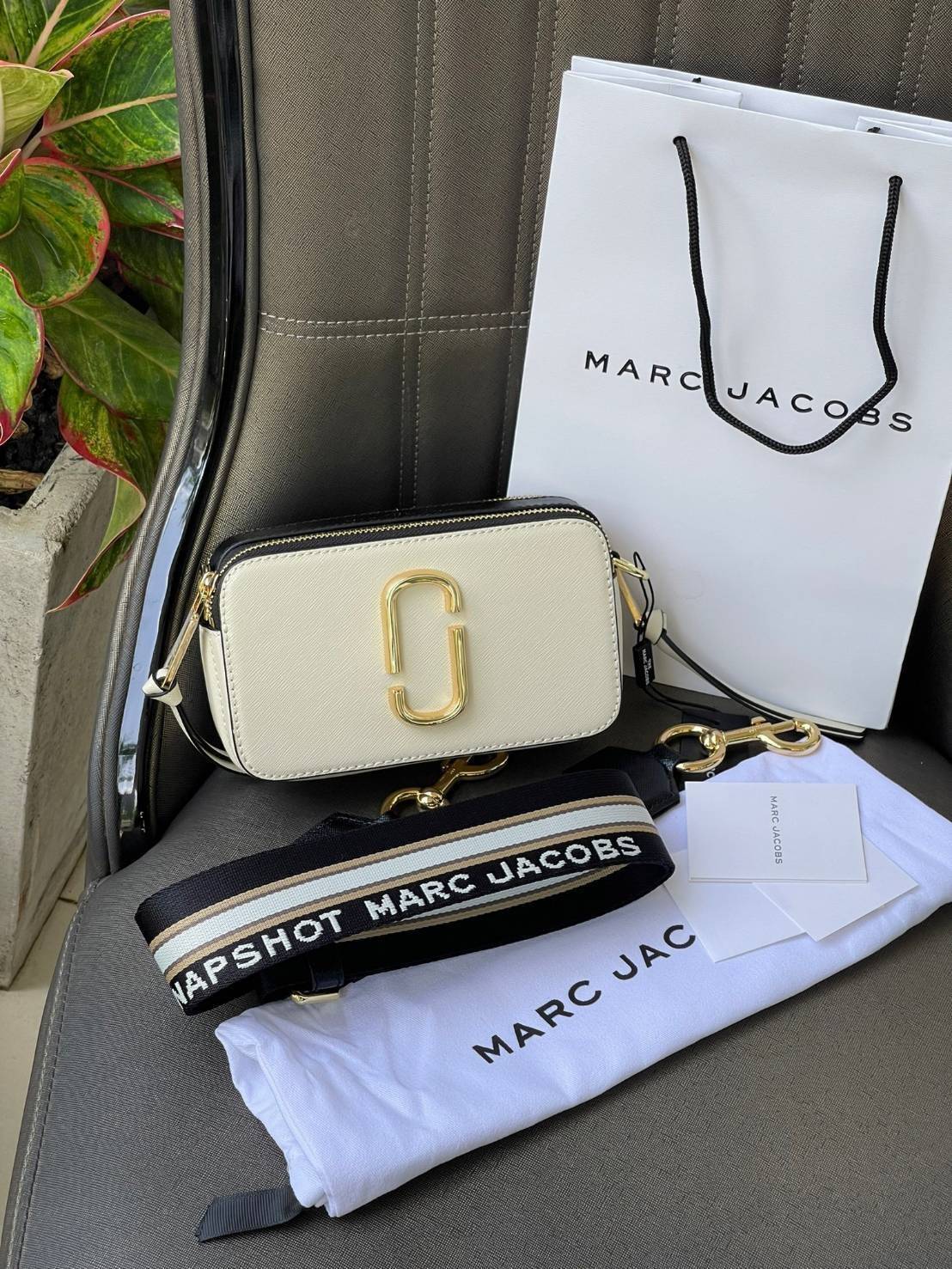 Marc Jacobs Snapshot Bag กระเป๋าแบรนด์ดังจากสัญชาติอเมริกัน นับได้ว่ารุ่นนี้เป็นรุ่นทรงฮิตเลยทีเดียว โดยด้านหน้ากระเป๋าจะเป็นโลโก้แบบโลหะที่เป็นสัญลักษณ์ของแบรนด์นี้ มาพร้อมสายสะพายที่จะสะพายยังไงก็ดูโดดเด่น เพราะขนาดใหญ่ที่สกรีนตัวอักษรโลโก้ ในรูปแบบต่าง