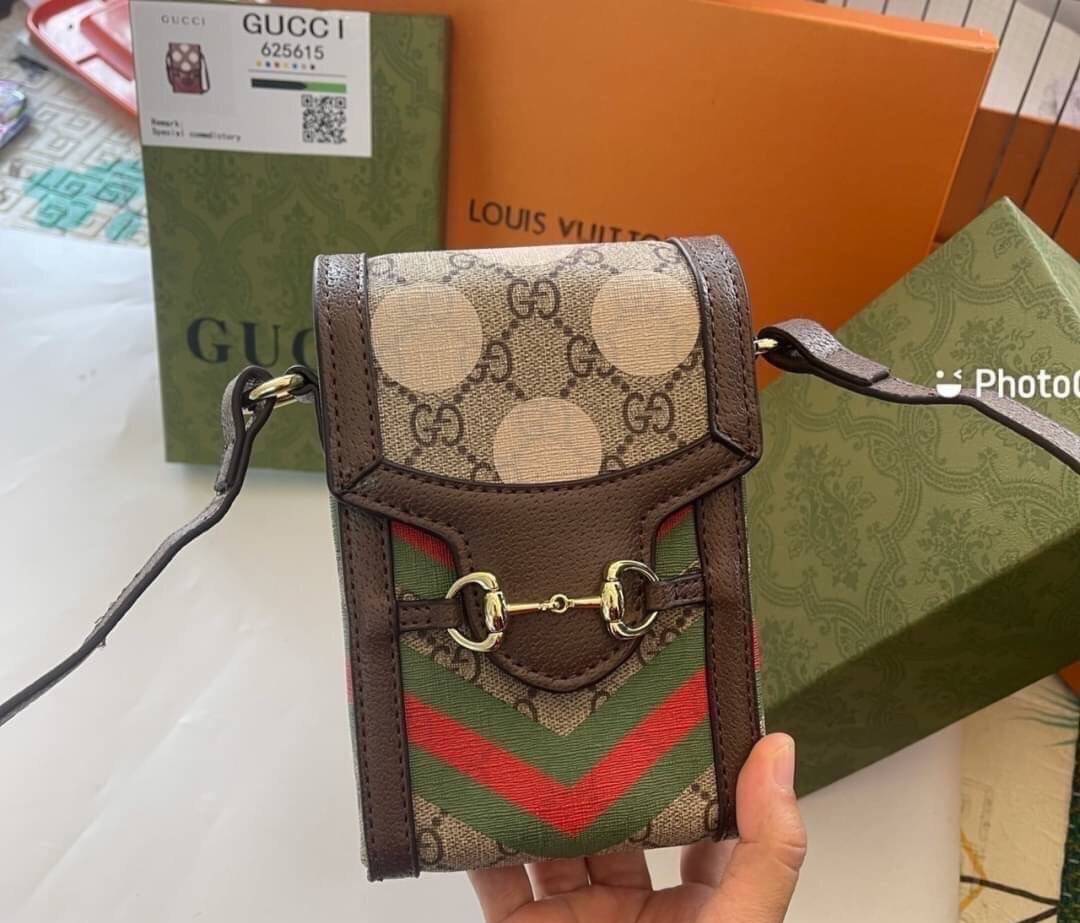 VIP 】GG CANVAS AND LEATHER CROSS-BODY PHONE BAG พร้อมส่งที่ไทย Brown canvas Brown Ophidia GG Supreme mini bag from GUCCI featuring an adjustable shoulder strap, a foldover top, a GG Supreme pattern, a Web stripe to the front and a gold-tone Double G plaqu